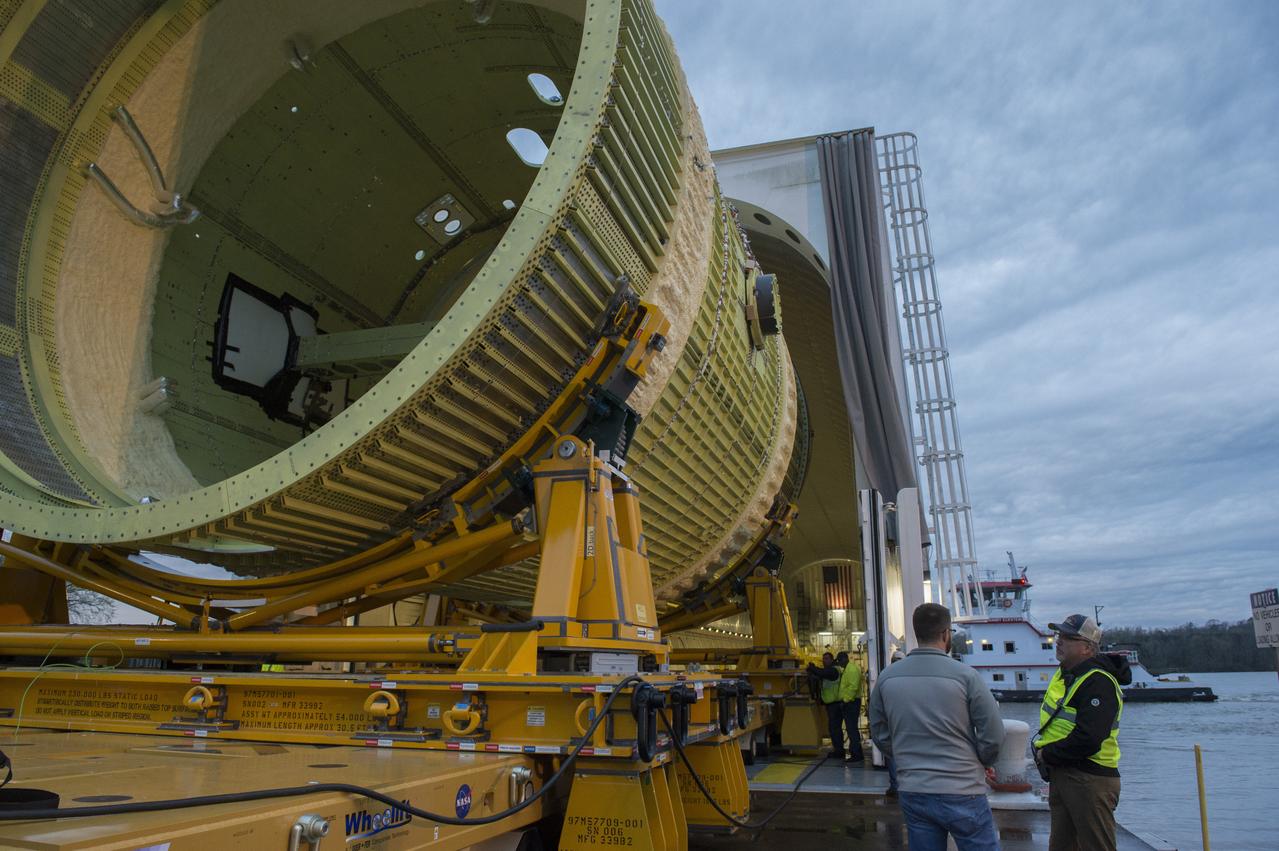 The SLS Stages Intertank Structural Test Assembly (STA) is rolling off the NASA Pegasus Barge at the MSFC Dock enroute to the MSFC 4619 Load Test Annex test facility for qualification testing