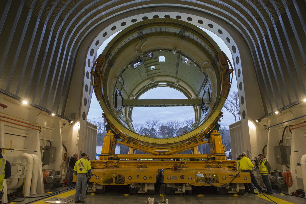 The SLS Stages Intertank Structural Test Assembly (STA) is rolling off the NASA Pegasus Barge at the MSFC Dock enroute to the MSFC 4619 Load Test Annex test facility for qualification testing