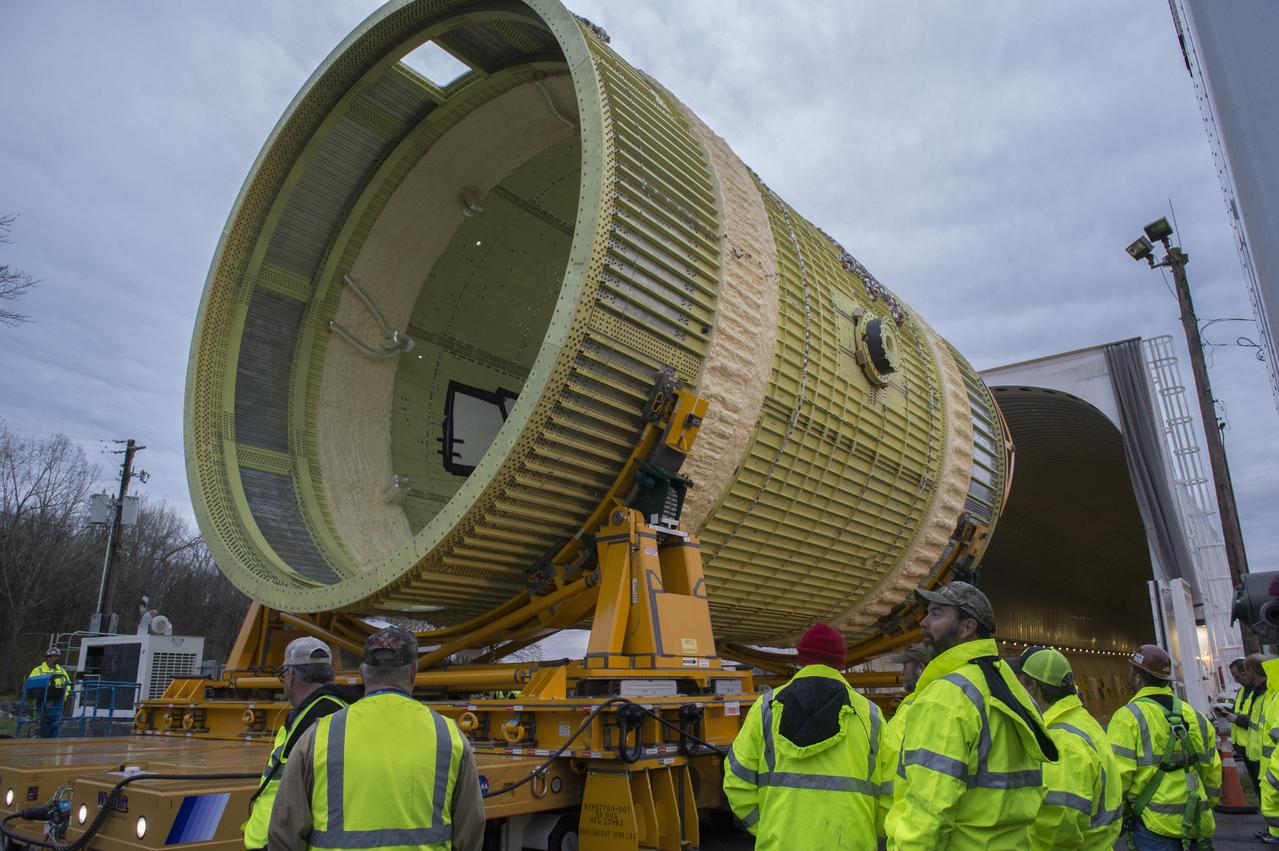 The SLS Stages Intertank Structural Test Assembly (STA) is rolling off the NASA Pegasus Barge at the MSFC Dock enroute to the MSFC 4619 Load Test Annex test facility for qualification testing