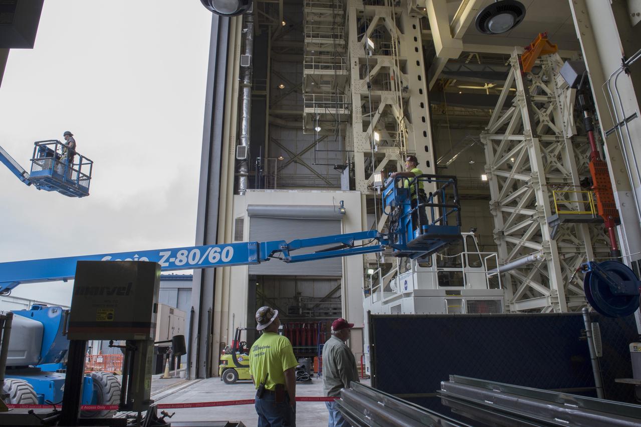 Technicians are removed from SLS Intertank Test Article, ITA, after attaching to crosshead of load test Annex, Bldg. 4619, 