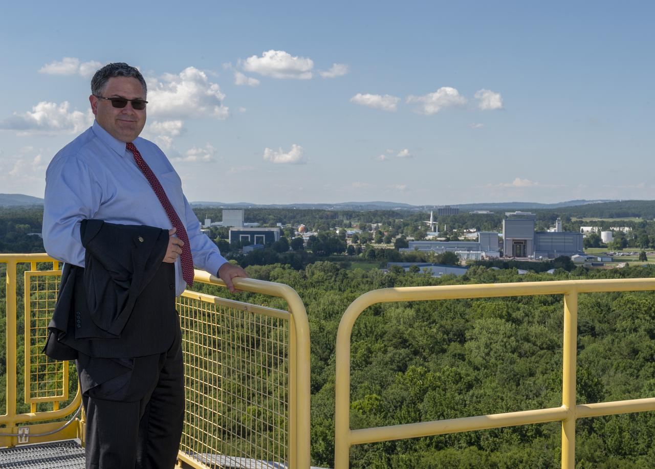 Retiring Marshall Space Flight Center Director Todd May on top of test stand 4693 in MSFC's west test area with MSFC in the background