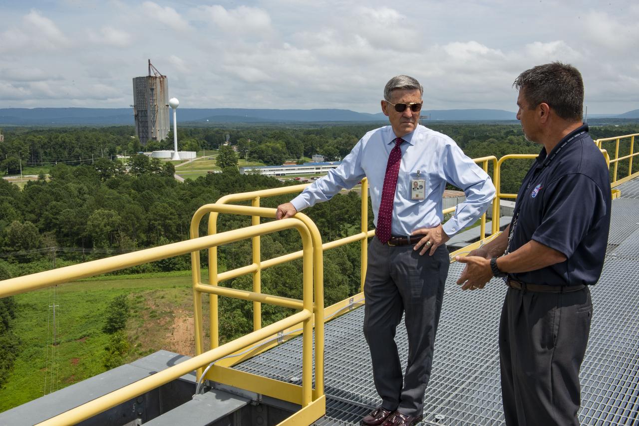 NASA's Kennedy Space Center Director Robert Cabana visited Marshall Space Flight Center July 16. With the Dynamic Test Stand in the background, Cabana, left, talks with Tim Flores, integration manager for stages in the Space Launch System Program Office, on top of Test Stand 4693, NASA’s largest SLS structural test stand. In addition to viewing SLS hardware, Cabana spoke to the Marshall Association and National Space Club Huntsville during his visit.