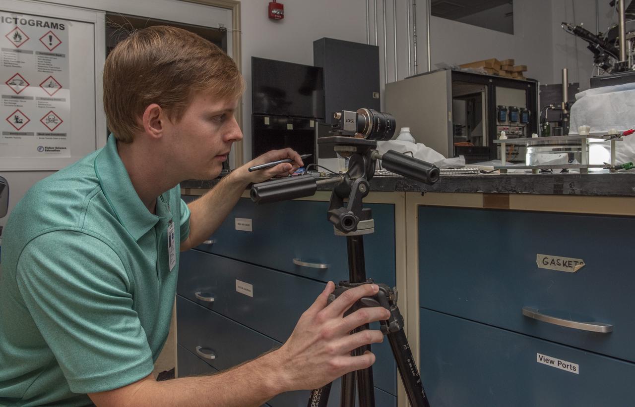 Evan Wilson (undergraduate student, University of Florida) observes a test apparatus to measure interfacial tension in support of Dr. Ranga Narayananâ€™s (University of Florida) NASA grant â€œA Novel Way to Measure Interfacial Tension Using the Electrostatic Levitation Furnace (ELF)â€ (NNX17AL27G).  