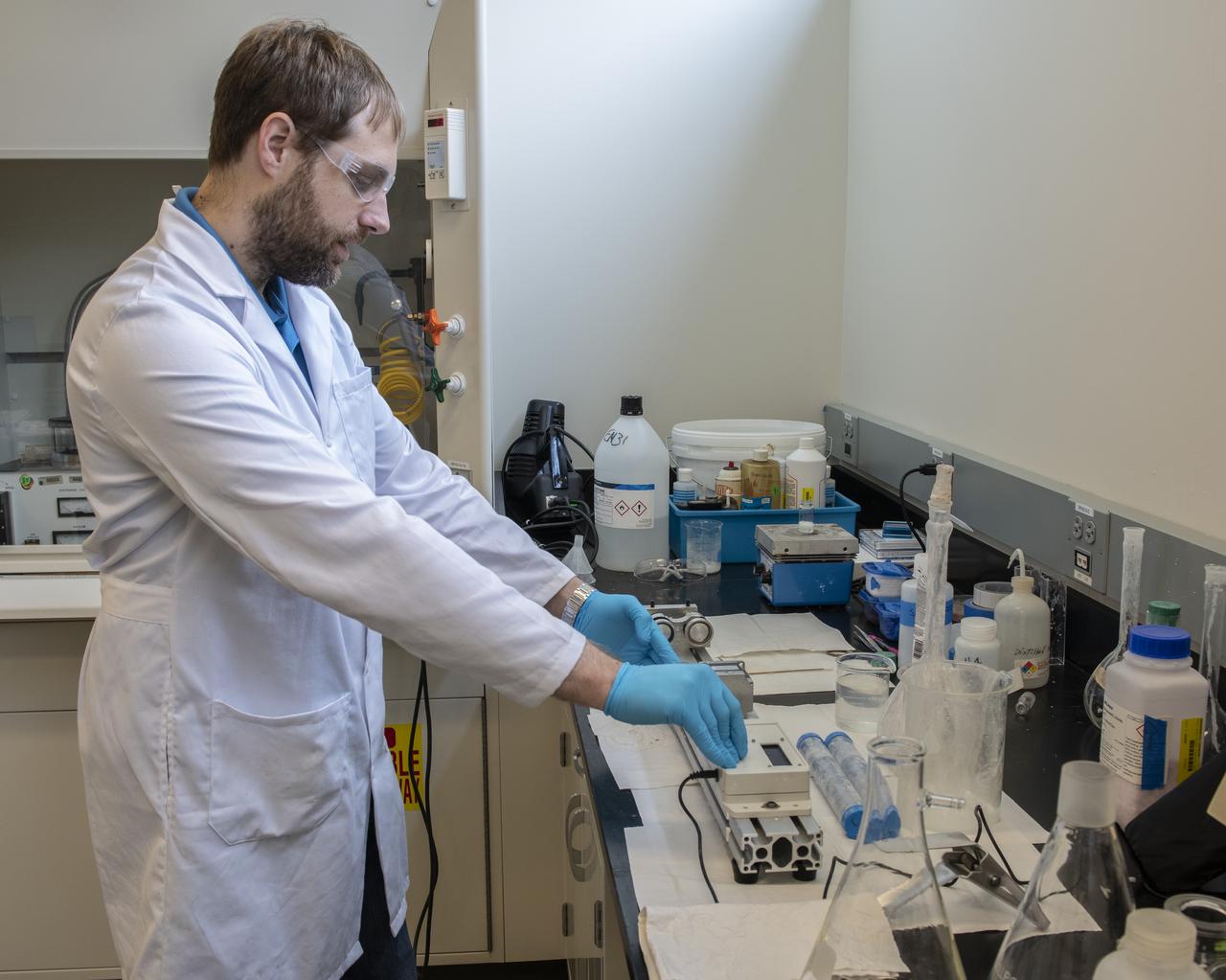 Alexander Blanchard, a chemistry doctoral student at Florida State University and graduate student at Marshall this summer, conducts analysis in a Marshall laboratory on the Chemical Gardens experiment, which is growing delicate crystalline structures in solution in the microgravity environment on the space station. Researchers hope the study could yield practical benefits for bioremediation and other "green" commercial applications.