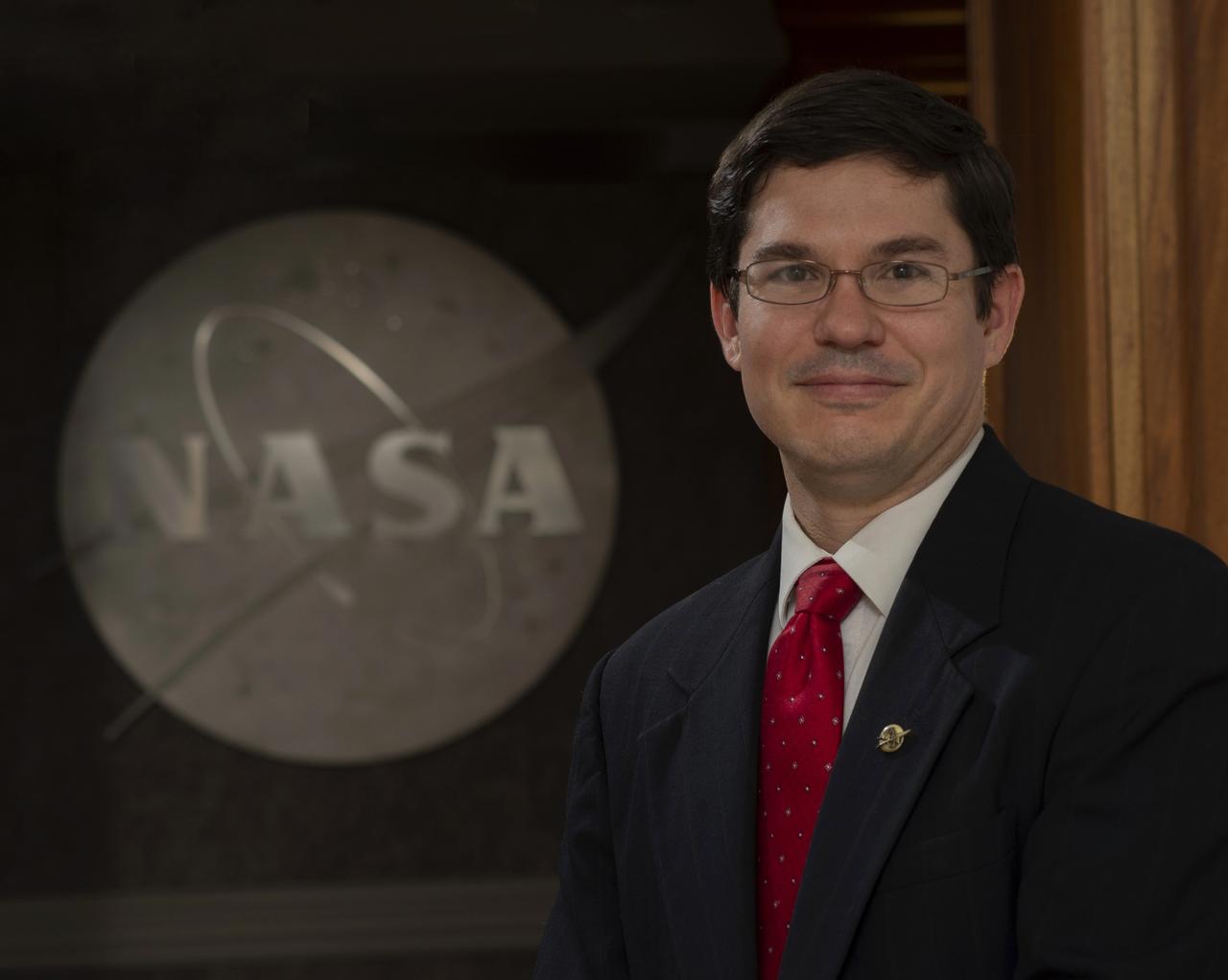 Jeremy Del Greco poses with NASA logo for use in his Management Intern Exit Presentation.