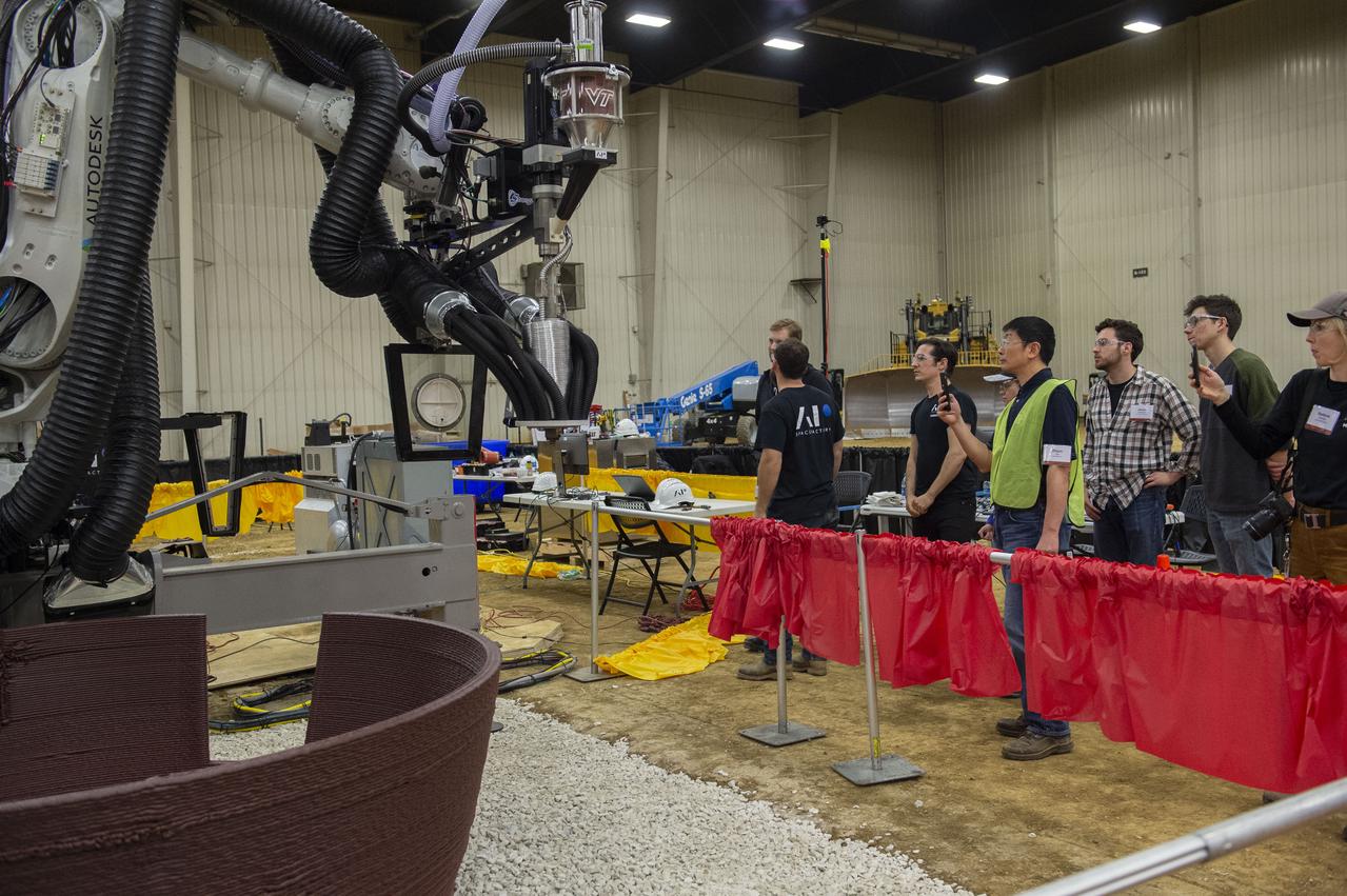 AI. SpaceFactory of New York and Pennsylvania State University of College Park print subscale habitat structures at NASA's 3D-Printed Habitat Challenge, held at the Caterpillar Edwards Demonstration & Learning Center in Edwards, Illinois, May 1-4, 2019. The habitat print is the final level of the multi-phase competition, which began in in 2015. The challenge is managed by NASA's Centennial Challenges program, and partner Bradley University of Peoria, Illinois.  First window placement in AI Spacefactory habitat.