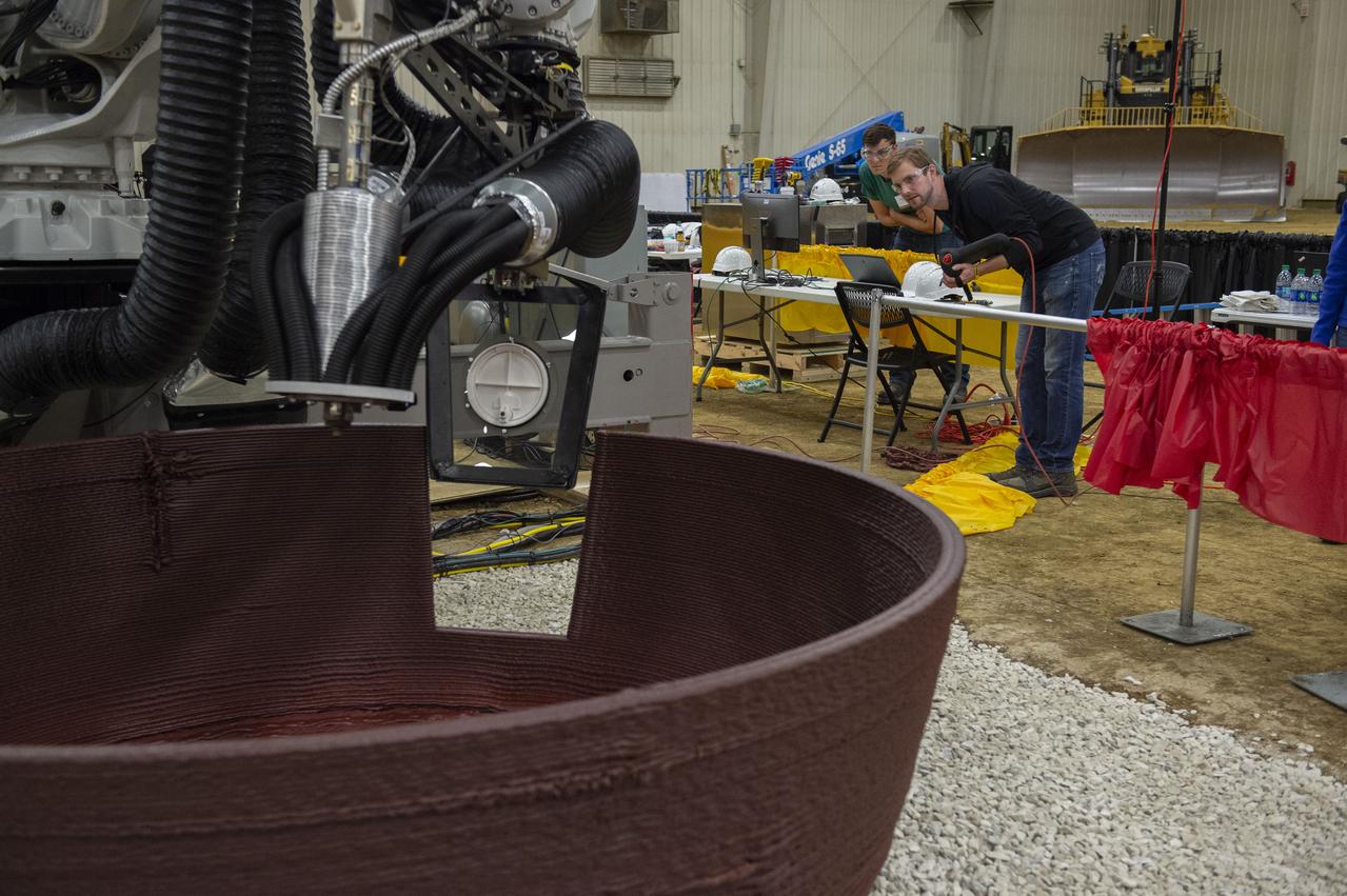 AI. SpaceFactory of New York and Pennsylvania State University of College Park print subscale habitat structures at NASA's 3D-Printed Habitat Challenge, held at the Caterpillar Edwards Demonstration & Learning Center in Edwards, Illinois, May 1-4, 2019. The habitat print is the final level of the multi-phase competition, which began in in 2015. The challenge is managed by NASA's Centennial Challenges program, and partner Bradley University of Peoria, Illinois.