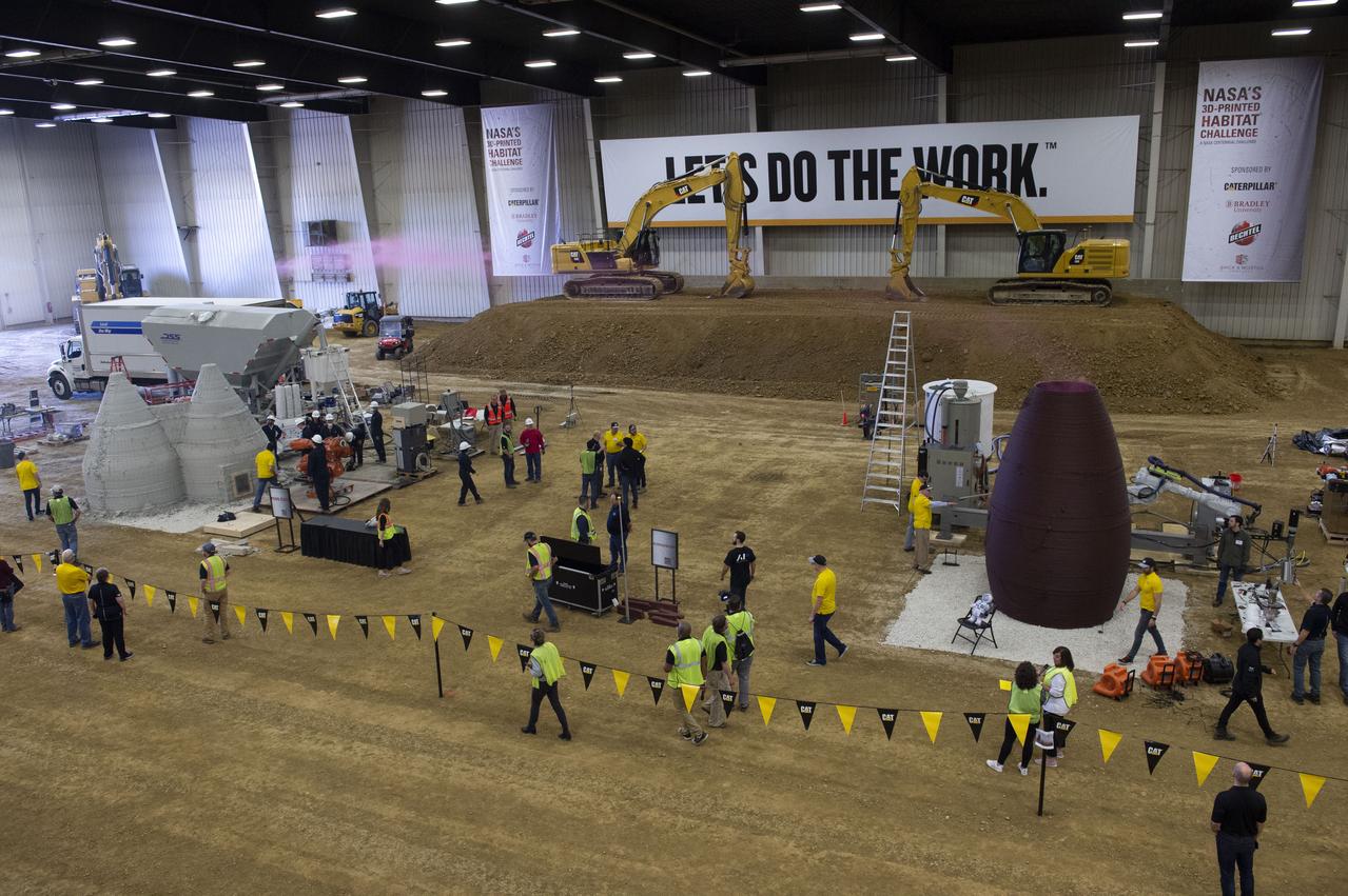 AI. SpaceFactory of New York and Pennsylvania State University of College Park print subscale habitat structures at NASA's 3D-Printed Habitat Challenge, held at the Caterpillar Edwards Demonstration & Learning Center in Edwards, Illinois, May 1-4, 2019. The habitat print is the final level of the multi-phase competition, which began in in 2015. The challenge is managed by NASA's Centennial Challenges program, and partner Bradley University of Peoria, Illinois.  Overview of arena and both 3D printed habitats during smoke test