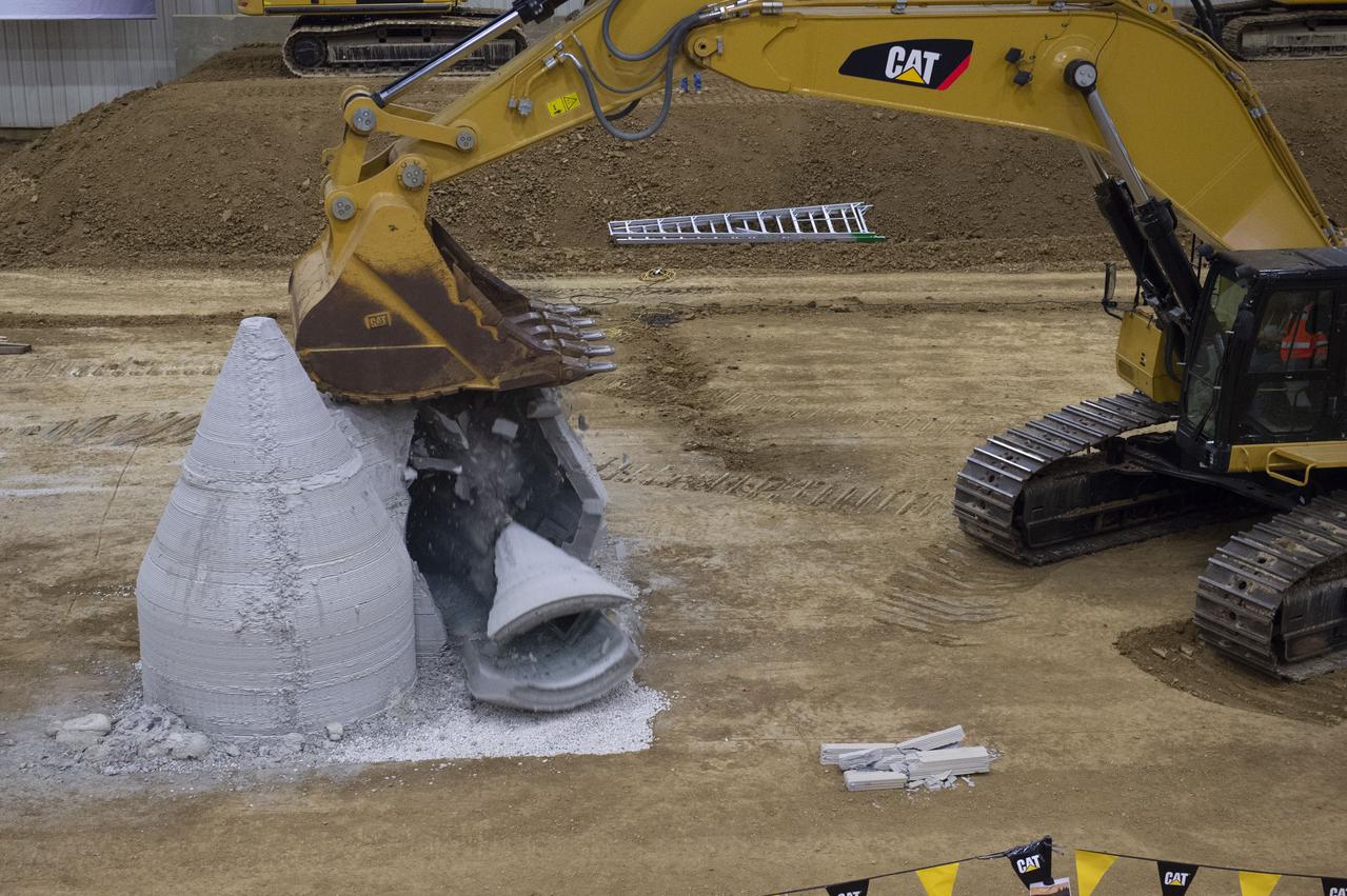 AI. SpaceFactory of New York and Pennsylvania State University of College Park print subscale habitat structures at NASA's 3D-Printed Habitat Challenge, held at the Caterpillar Edwards Demonstration & Learning Center in Edwards, Illinois, May 1-4, 2019. The habitat print is the final level of the multi-phase competition, which began in in 2015. The challenge is managed by NASA's Centennial Challenges program, and partner Bradley University of Peoria, Illinois.  