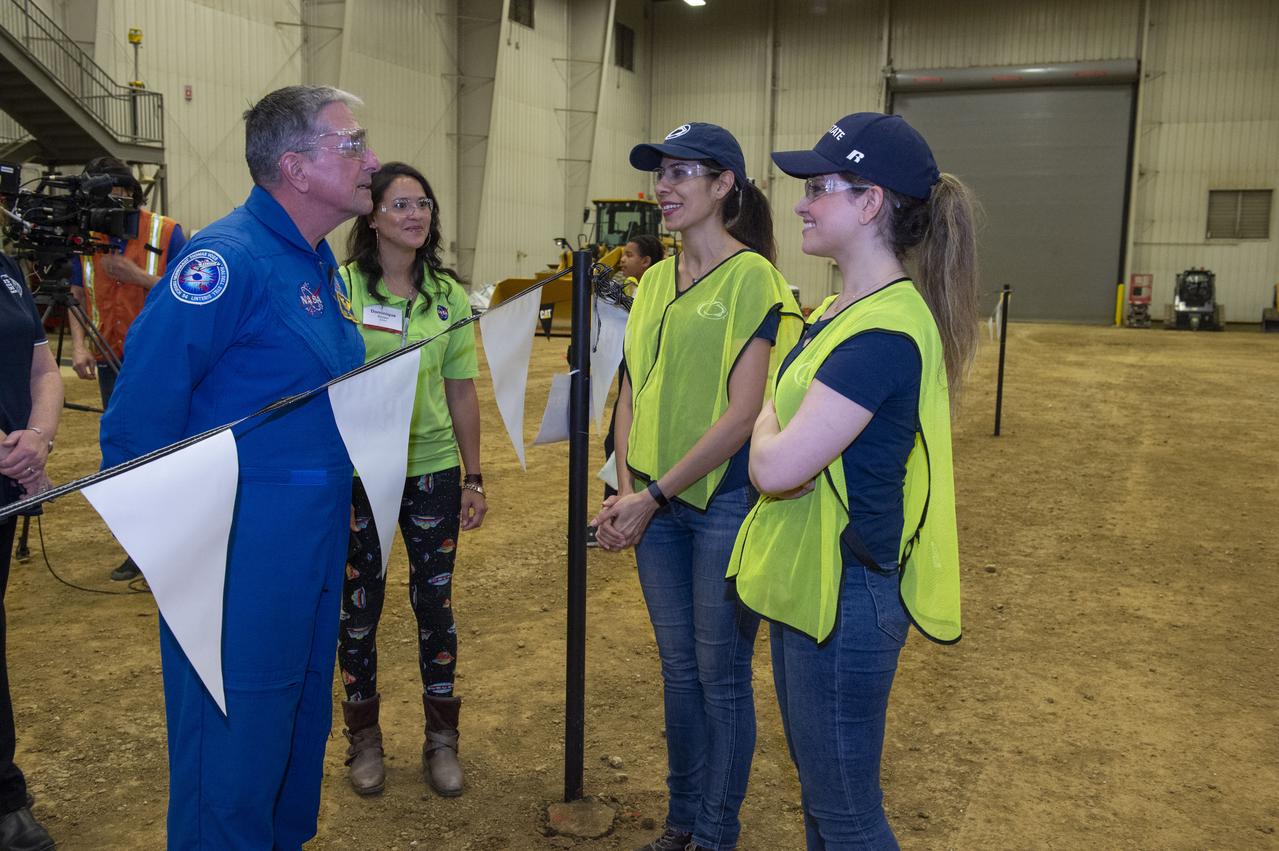 AI. SpaceFactory of New York and Pennsylvania State University of College Park print subscale habitat structures at NASA's 3D-Printed Habitat Challenge, held at the Caterpillar Edwards Demonstration & Learning Center in Edwards, Illinois, May 1-4, 2019. The habitat print is the final level of the multi-phase competition, which began in in 2015. The challenge is managed by NASA's Centennial Challenges program, and partner Bradley University of Peoria, Illinois. Astronaut Don Thomas talks with Penn State team members Negar Ashrafi and Maryam Hojati.