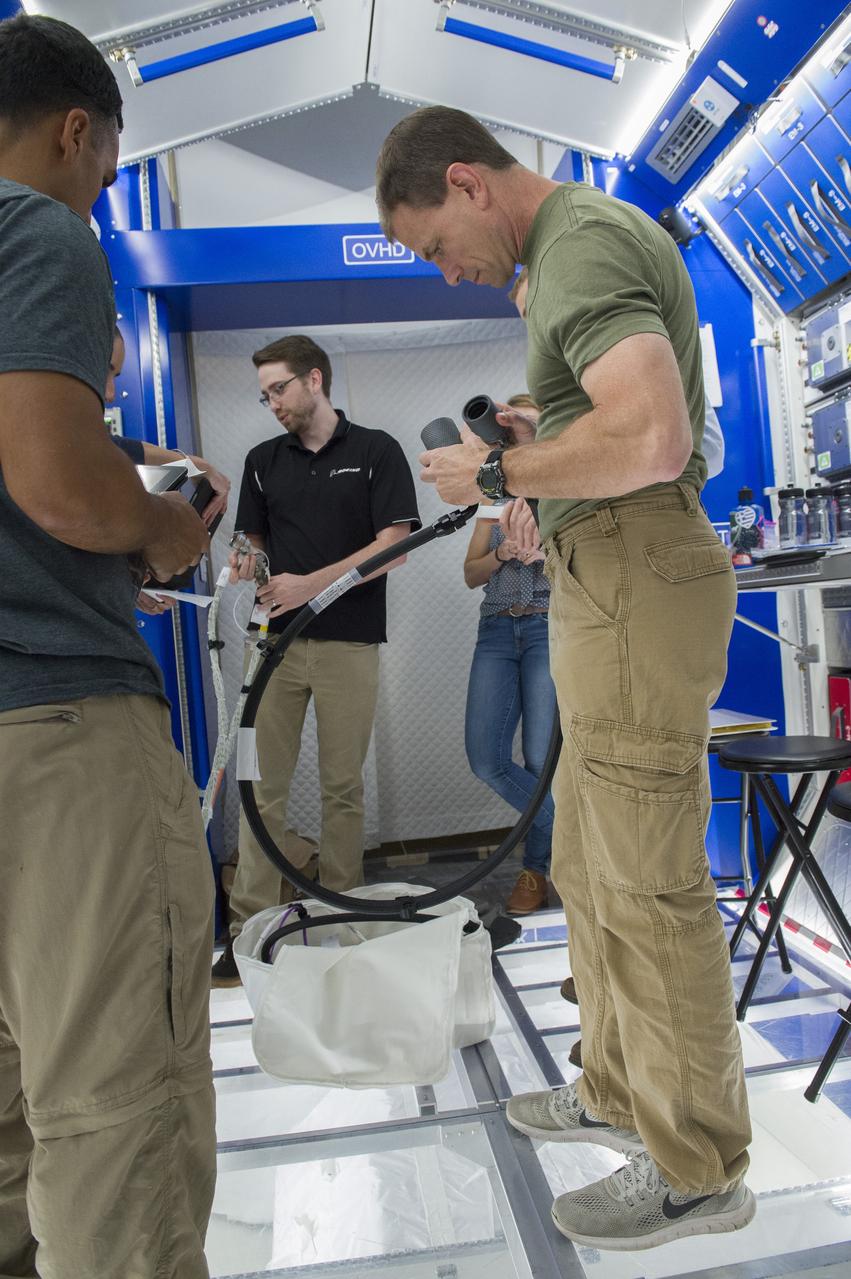Boeing trainers conduct simulations inside the Boeing Exploration Habitat Demonstrator with astronauts to evaluate the internal layout and ergonomics, to support efficient work-life balance aboard a deep space ship.
