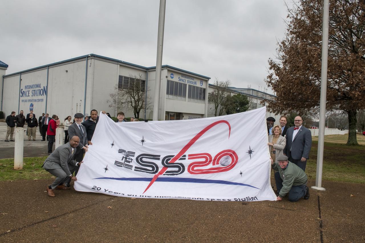 NASA Associate Administrator for the Human Exploration and Operations Mission Directorate and Marshall Center Director Jody Singer participate in the hanging of a new International Space Station flag out side of the Huntsville Operations Support Center (HOSC). Also participating were employees of the support center and the Payload Operations Integration Center.