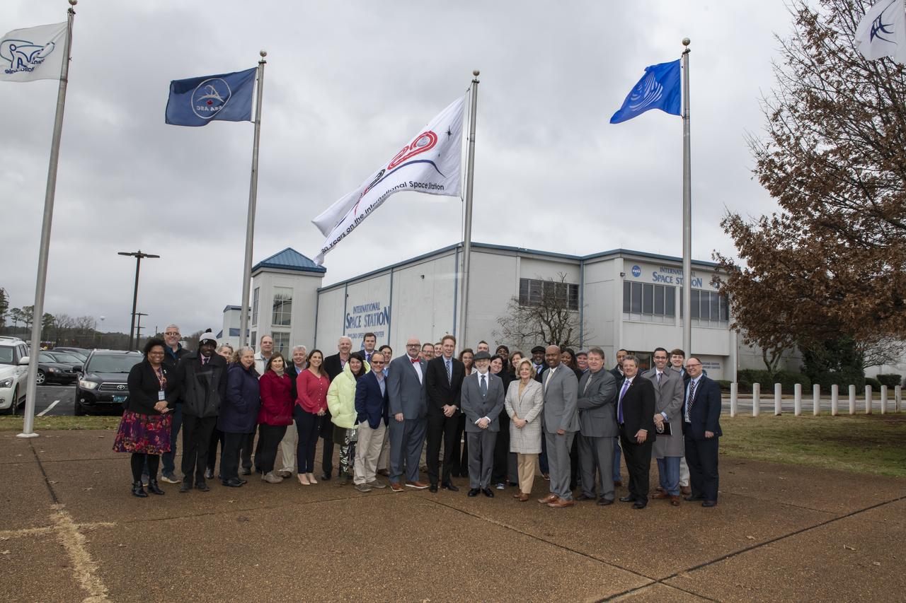 NASA Associate Administrator for the Human Exploration and Operations Mission Directorate and Marshall Center Director Jody Singer participate in the hanging of a new International Space Station flag out side of the Huntsville Operations Support Center (HOSC). Also participating were employees of the support center and the Payload Operations Integration Center.