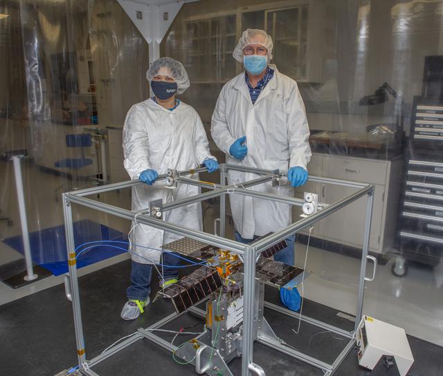 NASA image: Spacecraft in Gravity Off-load Fixture (GOLF), System Test configuration - Arisa Waddle – Test Engineer,  Rick Wilson – Lead Test Engineer