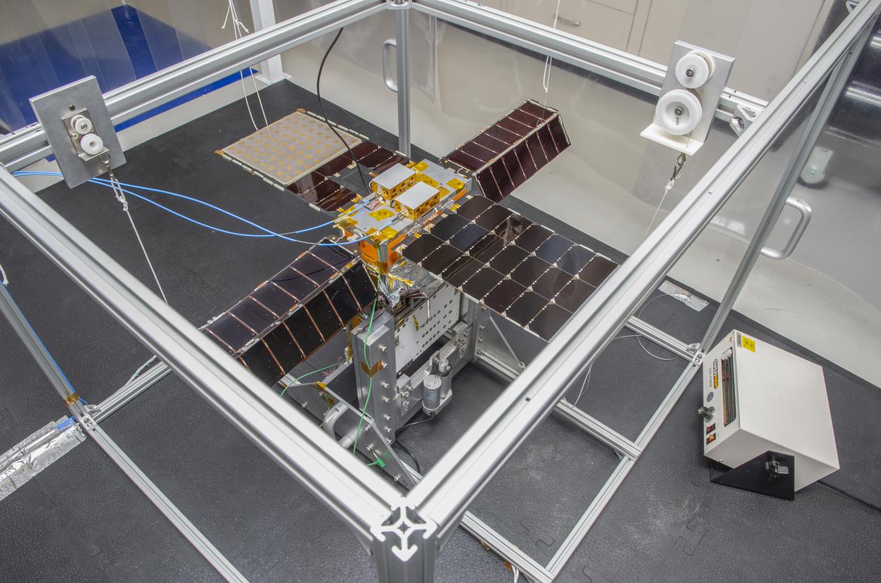 Spacecraft in Gravity Off-load Fixture (GOLF), System Test configuration - Arisa Waddle – Test Engineer,  Rick Wilson – Lead Test Engineer