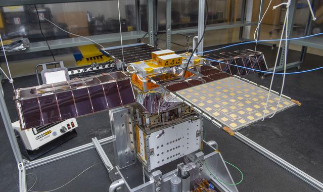 NASA image: Spacecraft in Gravity Off-load Fixture (GOLF), System Test configuration - Arisa Waddle – Test Engineer,  Rick Wilson – Lead Test Engineer