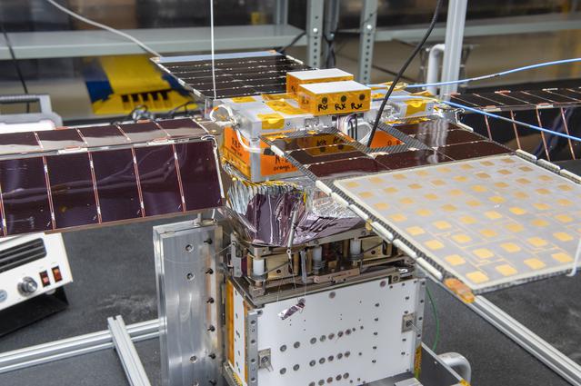 NASA image: Spacecraft in Gravity Off-load Fixture (GOLF), System Test configuration - Arisa Waddle – Test Engineer,  Rick Wilson – Lead Test Engineer