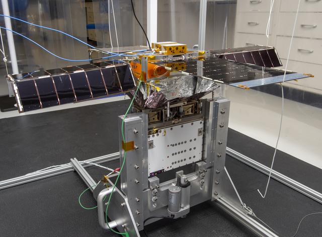 NASA image: Spacecraft in Gravity Off-load Fixture (GOLF), System Test configuration - Arisa Waddle – Test Engineer,  Rick Wilson – Lead Test Engineer