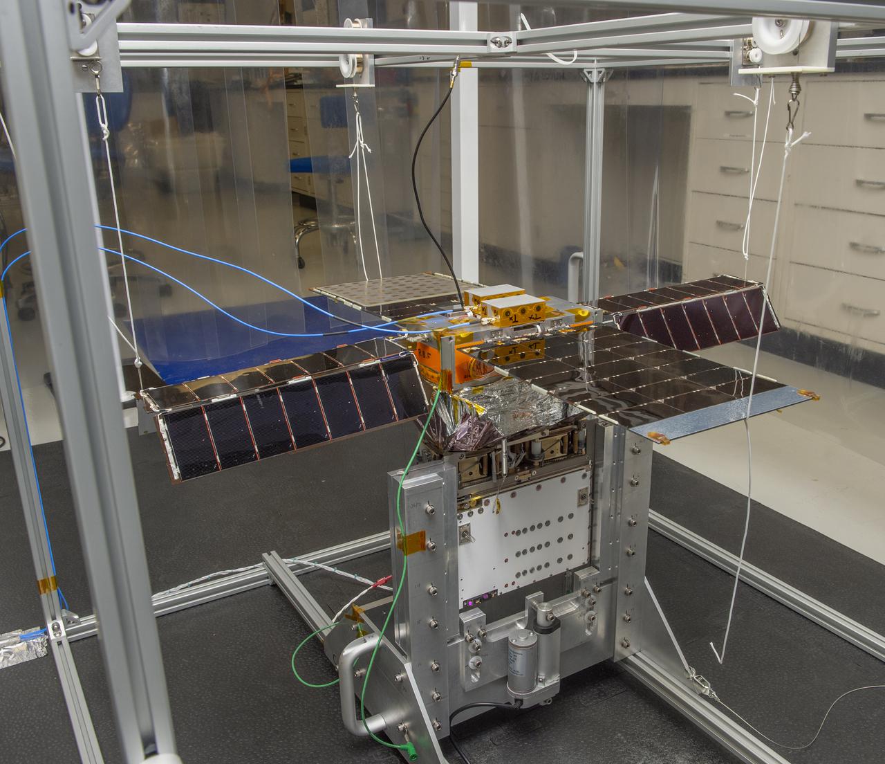 Spacecraft in Gravity Off-load Fixture (GOLF), System Test configuration - Arisa Waddle – Test Engineer,  Rick Wilson – Lead Test Engineer