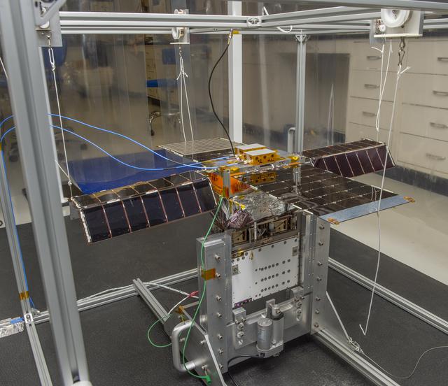 NASA image: Spacecraft in Gravity Off-load Fixture (GOLF), System Test configuration - Arisa Waddle – Test Engineer,  Rick Wilson – Lead Test Engineer