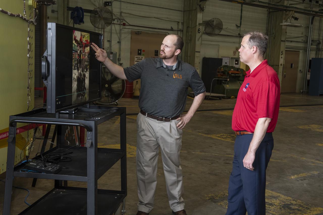 On August 15, 2018 NASA Administrator Jim Bridenstine visited Marshall Space Flight Center. Upon his arrival he was greeted by MSFC Acting Director Jody Singer along with the senior management team. Lead test engineer for the Space Launch System core stage intertank, Matt Cash briefs NASA Administrator Jim Bridenstine on testing progress of the SLS test article in the Structural Strength Lab at Marshall. The test article is structurally identical to the flight version of the intertank that will connect the core stage's two colossal fuel tanks, serve as the upper-connection point for the two solid rocket boosters and house critical avionics and electronics.