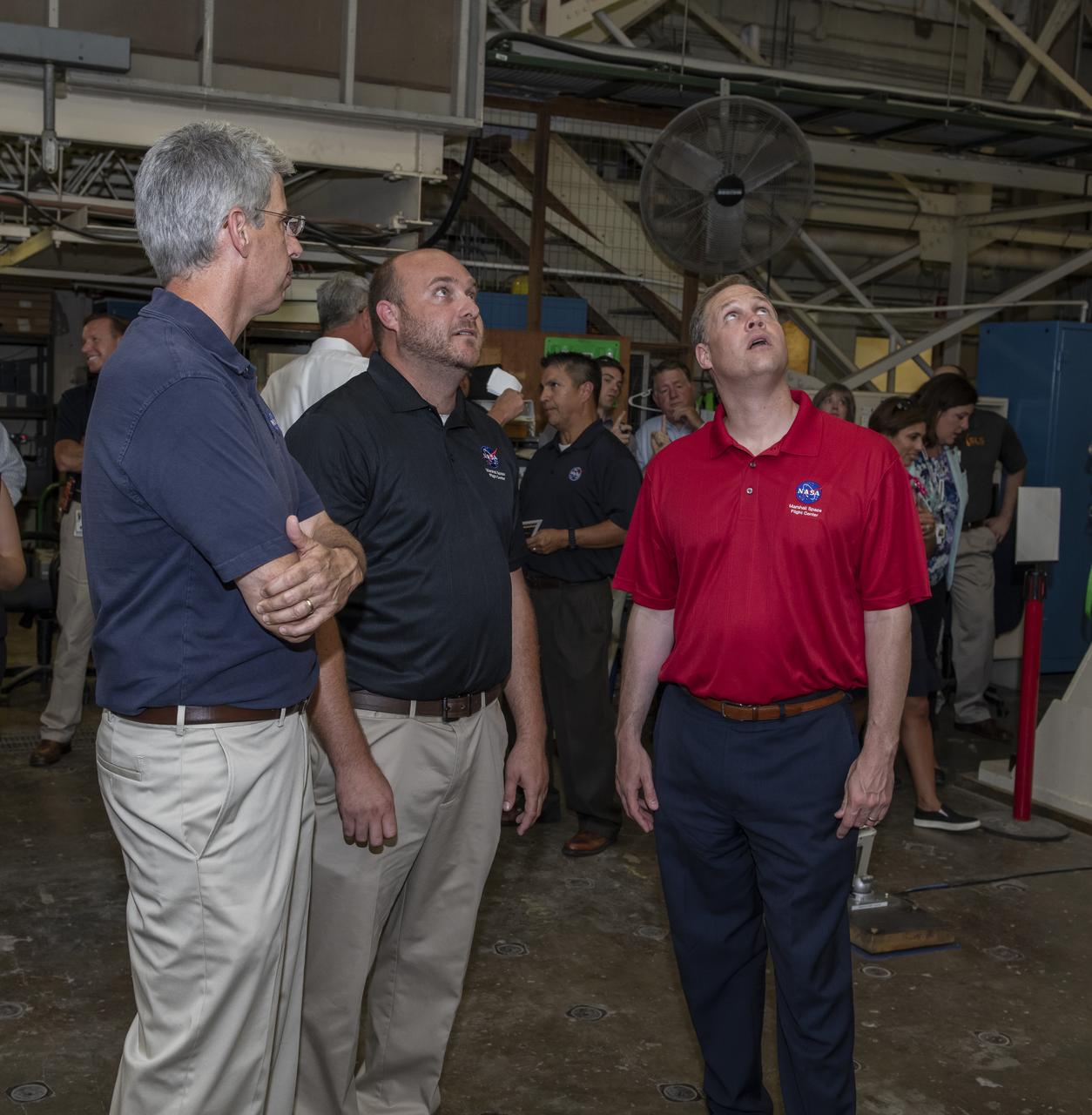 On August 15, 2018 NASA Administrator Jim Bridenstine visited Marshall Space Flight Center. Upon his arrival he was greeted by MSFC Acting Director Jody Singer along with the senior management team. Lead test engineer for the Space Launch System core stage intertank, Matt Cash briefs NASA Administrator Jim Bridenstine on testing progress of the SLS test article in the Structural Strength Lab at Marshall. The test article is structurally identical to the flight version of the intertank that will connect the core stage's two colossal fuel tanks, serve as the upper-connection point for the two solid rocket boosters and house critical avionics and electronics. 
