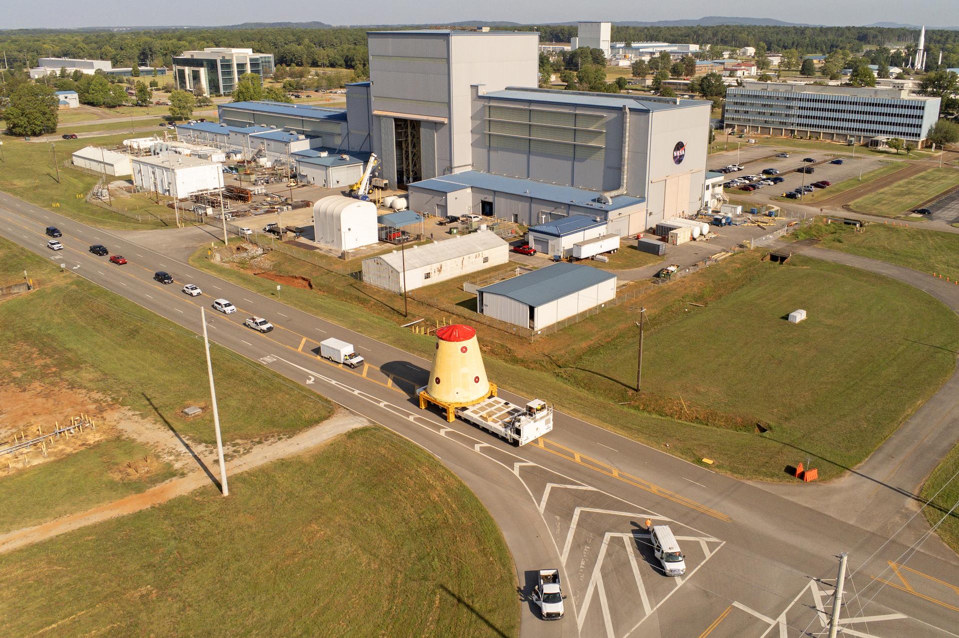 These images and videos show NASA rolling out a key piece of space flight hardware for the SLS (Space Launch System) rocket for the first crewed mission of NASA’s Artemis campaign from Marshall Space Flight Center in Huntsville, Alabama, on Wednesday, Aug. 21 for shipment to the agency’s spaceport in Florida. The cone-shaped launch vehicle stage adapter connects the rocket’s core stage to the upper stage and helps protect the upper stage’s engine that will help propel the Artemis II test flight around the Moon, slated for 2025. Manufactured by prime contractor Teledyne Brown Engineering and the Jacobs Space Exploration Group’s ESSCA (Engineering Services and Science Capability Augmentation) contract using NASA Marshall’s self-reacting friction-stir robotic and vertical weld tools. Crews moved the adapter out of NASA Marshall’s Building 4708 to the agency’s Pegasus barge Aug. 21. The barge will ferry the adapter first to NASA’s Michoud Assembly Facility in New Orleans, where crews will pick up additional SLS hardware for future Artemis missions, before traveling to NASA Kennedy. Once in Florida, the adapter will join the recently delivered core stage. There, teams with NASA’s Exploration Ground Systems will prepare the adapter for stacking and launch.