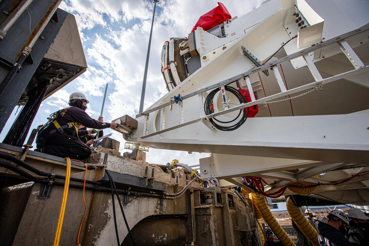 Personnel prepare to mate the Transporter-Erector-Launcher, also called the TEL, carrying a Northrop Grumman Antares rocket to the launch mount on the Mid-Atlantic Regional Spaceport’s Pad 0A at NASA’s Wallops Flight Facility in Virginia. The Antares arrived at the launch pad on Tuesday, Feb. 16, in preparation for launch at 12:36 p.m. EST, Feb. 20, 2021. The launch will be Northrop Grumman’s 15th contracted cargo resupply mission with NASA to the International Space Station, carrying about 8,000 pounds of science and research, crew supplies and vehicle hardware to the orbital laboratory and its crew. Antares is carrying the company’s CRS-15 Cygnus cargo spacecraft named after NASA mathematician, Katherine Johnson, a Black woman who time and again broke through barriers of gender and race. Photo Credit: (NASA/Patrick Black)