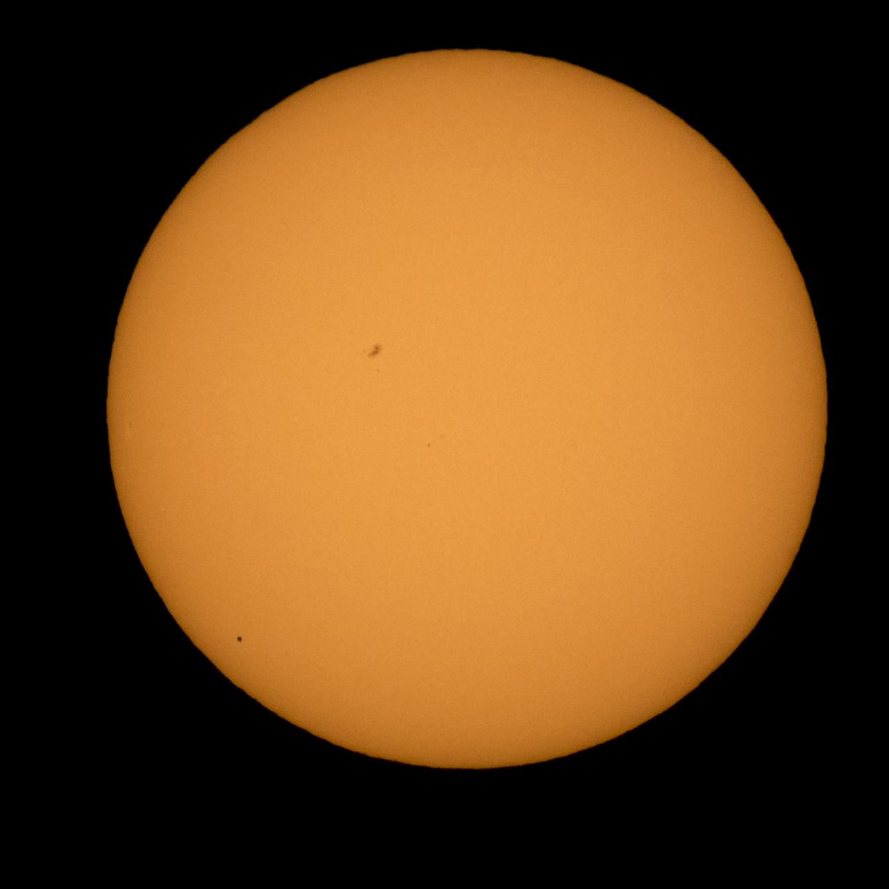 The planet Mercury is seen in silhouette, lower left, as it transits across the face of the sun Monday, May 9, 2016, as viewed from Boyertown, Pennsylvania.  Mercury passes between Earth and the sun only about 13 times a century, with the previous transit taking place in 2006.  Photo Credit: (NASA/Bill Ingalls)