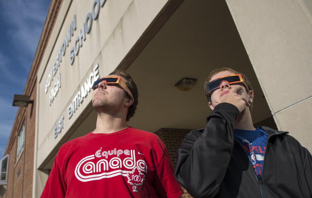 Boyertown Area High School students, 12th grader Bransen Mackey, left, and 11th grader Nick Cioppi wear solar safety glasses and attempt to see the planet Mercury as it transits across the face of the sun, Monday, May 9, 2016, Boyertown, Pennsylvania.  Mercury passes between Earth and the sun only about 13 times a century, with the previous transit taking place in 2006.  Photo Credit: (NASA/Bill Ingalls)