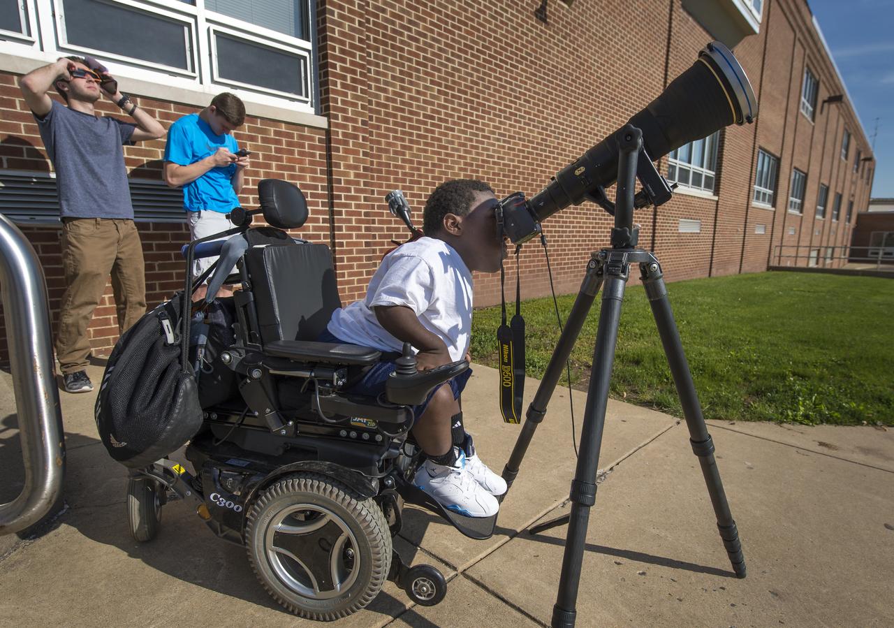Boyertown Area High School 12th grade student Jay Hallman looks through a photographers lens and solar filter to see the planet Mercury as it transits across the face of the sun , Monday, May 9, 2016, Boyertown area High School, Boyertown, Pennsylvania.  Mercury passes between Earth and the sun only about 13 times a century, with the previous transit taking place in 2006.  Photo Credit: (NASA/Bill Ingalls)