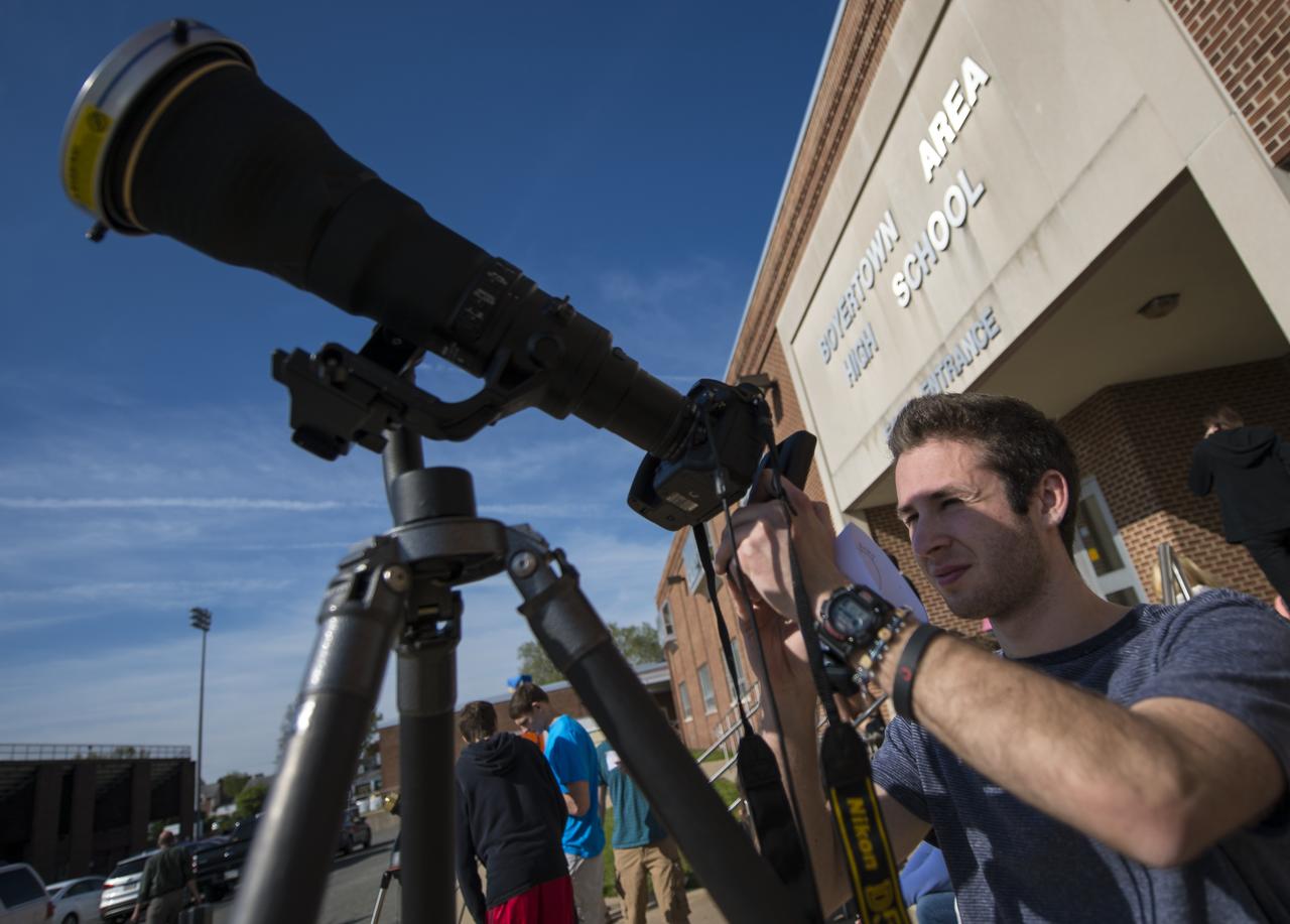 Boyertown Area High School 12th grade student Ben Maurer uses his smartphone and a photographers lens with a solar filter to make a photograph of the planet Mercury transitting the sun, Monday, May 9, 2016, Boyertown area High School, Boyertown, Pennsylvania.  Mercury passes between Earth and the sun only about 13 times a century, with the previous transit taking place in 2006.  Photo Credit: (NASA/Bill Ingalls)
