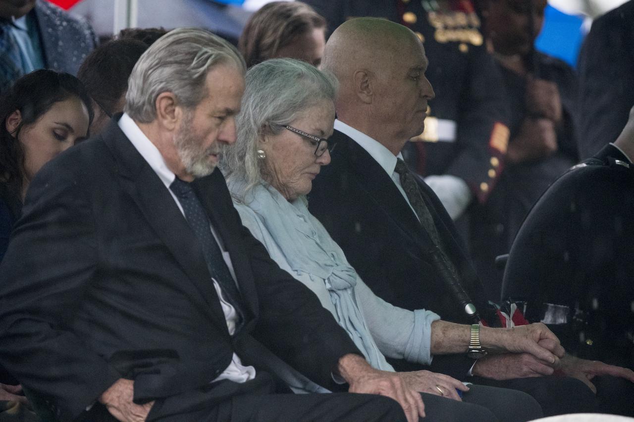 Lyn Glenn, center, and David Glenn, right, daughter and son of the former astronaut and U.S. Senator John Glenn are seen as their father is laid to rest during a full military honors interment ceremony at Arlington National Cemetery on Thursday, April 6, 2017 in Virginia. He was the first American to orbit Earth on Feb. 20, 1962, in a five-hour flight aboard the Friendship 7 spacecraft. In 1998, Glenn broke another record by returning to space at the age of 77 on the Space Shuttle Discovery.  Photo Credit: (NASA/Aubrey Gemignani)