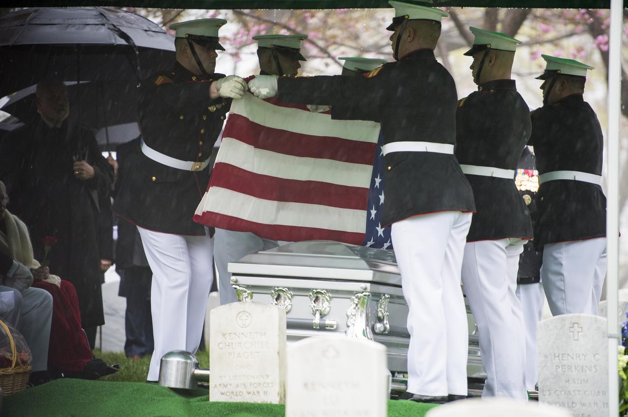 A Marine Corps honor guard folds the colors during a funeral service for former astronaut and U.S. Senator John Glenn, who was buried with full military honors, at Arlington National Cemetery in Virginia on Thursday, April 6, 2017, the day on which he and his wife Annie were married in 1943. Glenn was the first American to orbit Earth on Feb. 20, 1962, in a five-hour flight aboard the Friendship 7 spacecraft. In 1998, he broke another record by returning to space at the age of 77 on the Space Shuttle Discovery. Photo Credit: (NASA/Aubrey Gemignani)