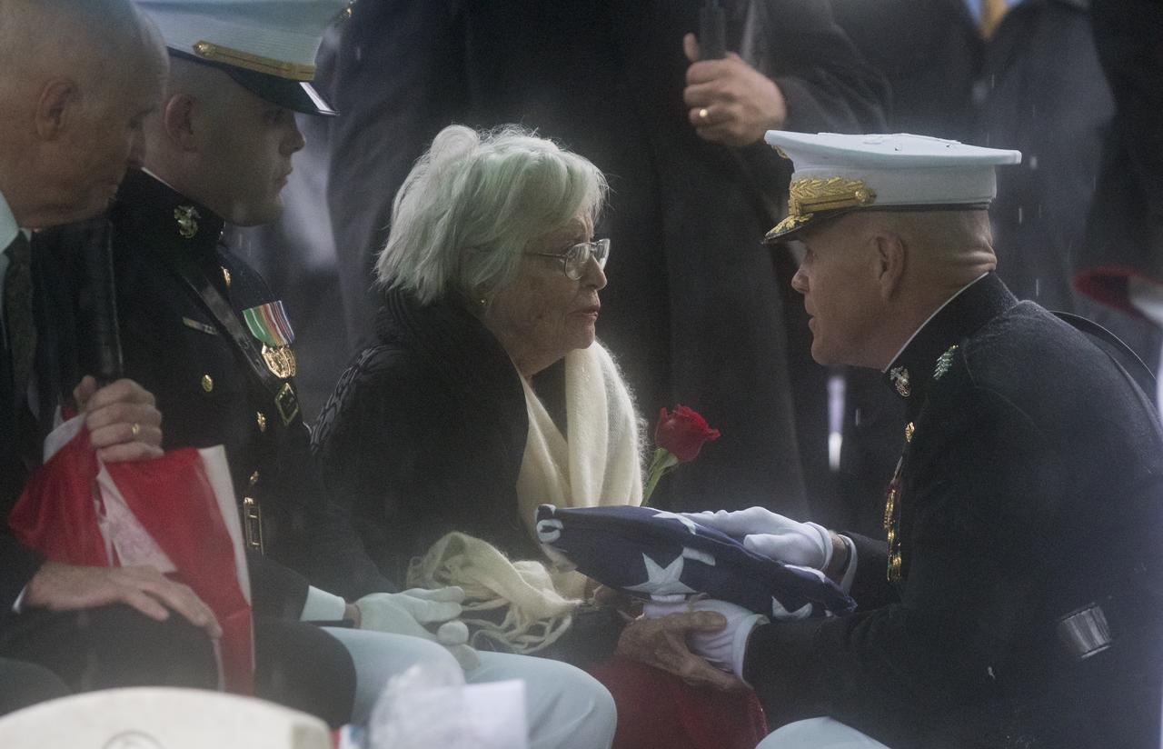 Annie Glenn, wife of former astronaut and U.S. Senator John Glenn receives the folded American flag from Commandant of the U.S. Marine Corps, General Robert B. Neller, during a graveside interment ceremony at Arlington National Cemetery in Virginia on Thursday, April 6, 2017, the day on which Glenn and Annie were married in 1943. He was the first American to orbit Earth on Feb. 20, 1962, in a five-hour flight aboard the Friendship 7 spacecraft. In 1998, Glenn broke another record by returning to space at the age of 77 on the Space Shuttle Discovery. Photo Credit: (NASA/Aubrey Gemignani)