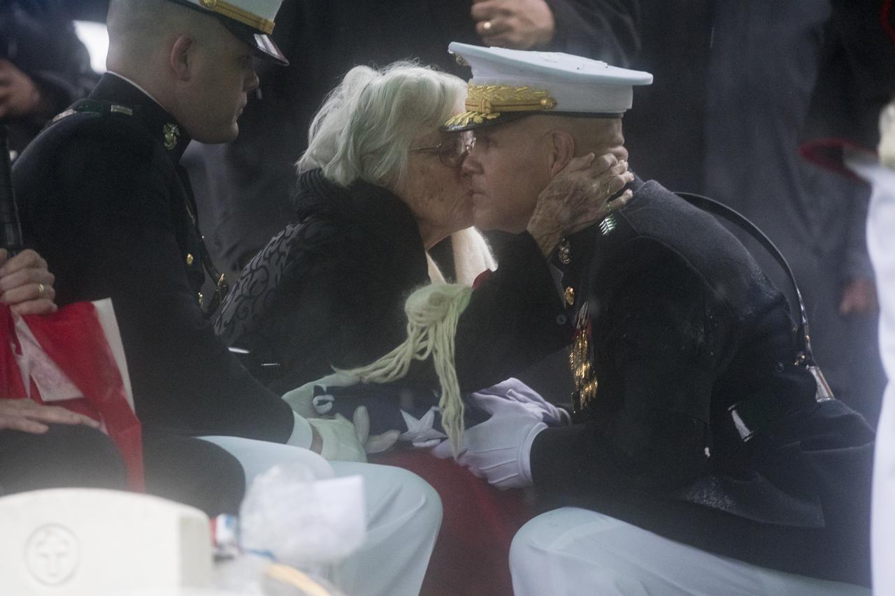 Annie Glenn, wife of former astronaut and U.S. Senator John Glenn gives the   Commandant of the U.S. Marine Corps, General Robert B. Neller, a kiss on the cheek after he handed her the folded American flag during a graveside interment ceremony at Arlington National Cemetery in Virginia on Thursday, April 6, 2017, the day on which Glenn and Annie were married in 1943. He was the first American to orbit Earth on Feb. 20, 1962, in a five-hour flight aboard the Friendship 7 spacecraft. In 1998, Glenn broke another record by returning to space at the age of 77 on the Space Shuttle Discovery. Photo Credit: (NASA/Aubrey Gemignani)