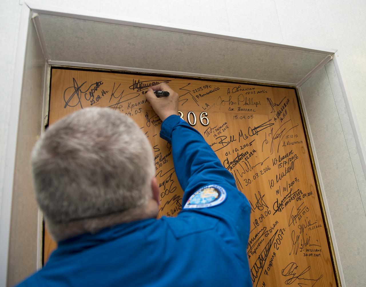 Expedition 51 Soyuz Commander Fyodor Yurchikhin of Roscosmos performs the traditional door signing at the Cosmonaut Hotel prior to departing the hotel for launch in a Soyuz rocket with fellow crew mate Flight Engineer Jack Fischer of NASA, Thursday, April 20, 2017 in Baikonur, Kazakhstan. Launch of the Soyuz rocket is scheduled for 1:13pm April 20 Baikonur time, and will carry Yurchikhin and Fischer into orbit to begin their four and a half month mission on the International Space Station. Photo Credit: (NASA/Aubrey Gemignani)