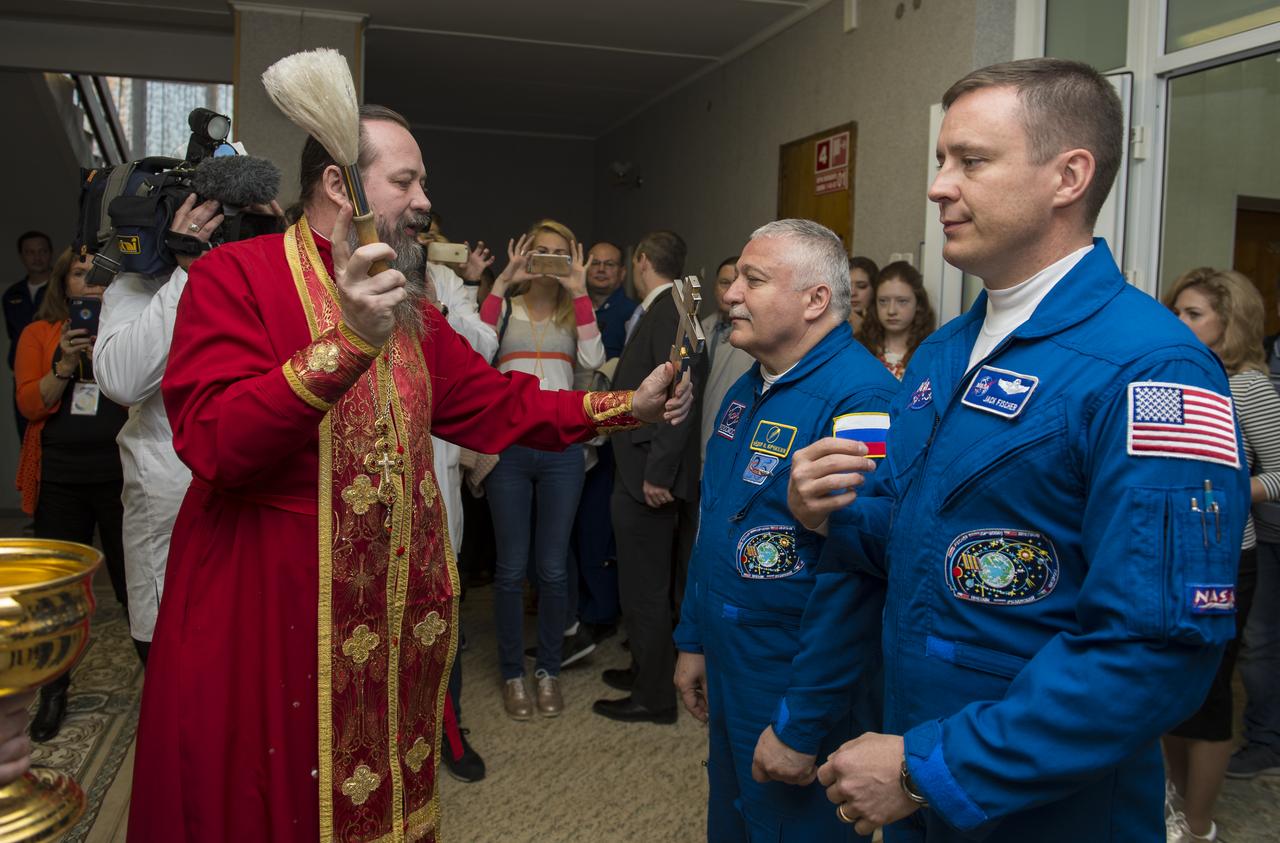 Expedition 51 Soyuz Commander Fyodor Yurchikhin of Roscosmos, left, receives the traditional blessing from a Russian Orthodox priest at the Cosmonaut Hotel prior to his launch on the Soyuz rocket to the International Space Station (ISS), Thursday, April 20, 2017, in Baikonur, Kazakhstan. He and fellow crew mate, Flight Engineer Jack Fischer of NASA, right, will spend the next four and a half months living and working aboard the ISS. Photo Credit: (NASA/Aubrey Gemignani)