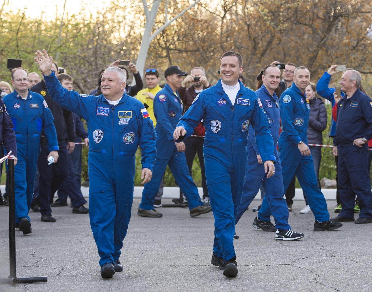 Expedition 51 crew members, Soyuz Commander Fyodor Yurchikhin of Roscosmos, left, and Flight Engineer Jack Fischer of NASA, right, wave farewell to family and friends as they depart the Cosmonaut Hotel to suit-up for their Soyuz launch to the International Space Station on Thursday, April 20, 2017 in Baikonur, Kazakhstan. Launch of the Soyuz rocket is scheduled for 1:13PM April 20 Baikonur time and will send Yurchikhin and Fischer on a four and a half month mission aboard the International Space Station. Photo Credit: (NASA/Aubrey Gemignani)