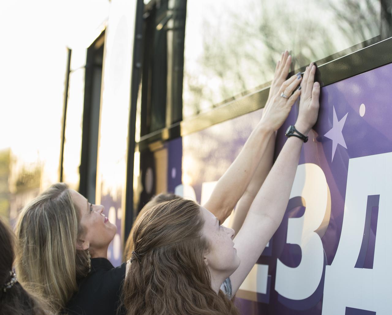 Expedition 51 Flight Engineer Jack Fischer's wife, Elizabeth Fischer, left, and daughters Sariah (not pictured) and Bethany, right, reach up to the bus window to bid farewell to Fischer as he departs the Cosmonaut Hotel to suit-up for his Soyuz launch to the International Space Station on Thursday, April 20, 2017 in Baikonur, Kazakhstan. Launch of the Soyuz rocket is scheduled for 1:13PM April 20 Baikonur time and will send Fischer and Soyuz Commander Fyodor Yurchikhin of Roscosmos on a four and a half month mission aboard the International Space Station. Photo Credit: (NASA/Aubrey Gemignani)