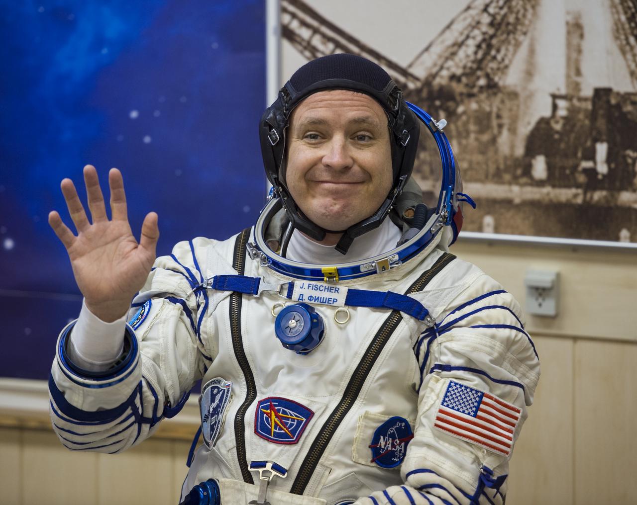 Expedition 51 Flight Engineer Jack Fischer of NASA waves to friends and family while he waits to have his Russian Sokol suit pressure checked in preparation for his launch aboard the Soyuz MS-04 spacecraft on Thursday, April 20, 2017 at the Baikonur Cosmodrome in Kazakhstan. Launch of the Soyuz rocket is scheduled for 1:13pm April 20 Baikonur time, and will carry Fischer and fellow crewmate, Soyuz Commander Fyodor Yurchikhin of Roscosmos into orbit to begin their four and a half month mission on the International Space Station. Photo Credit: (NASA/Aubrey Gemignani)
