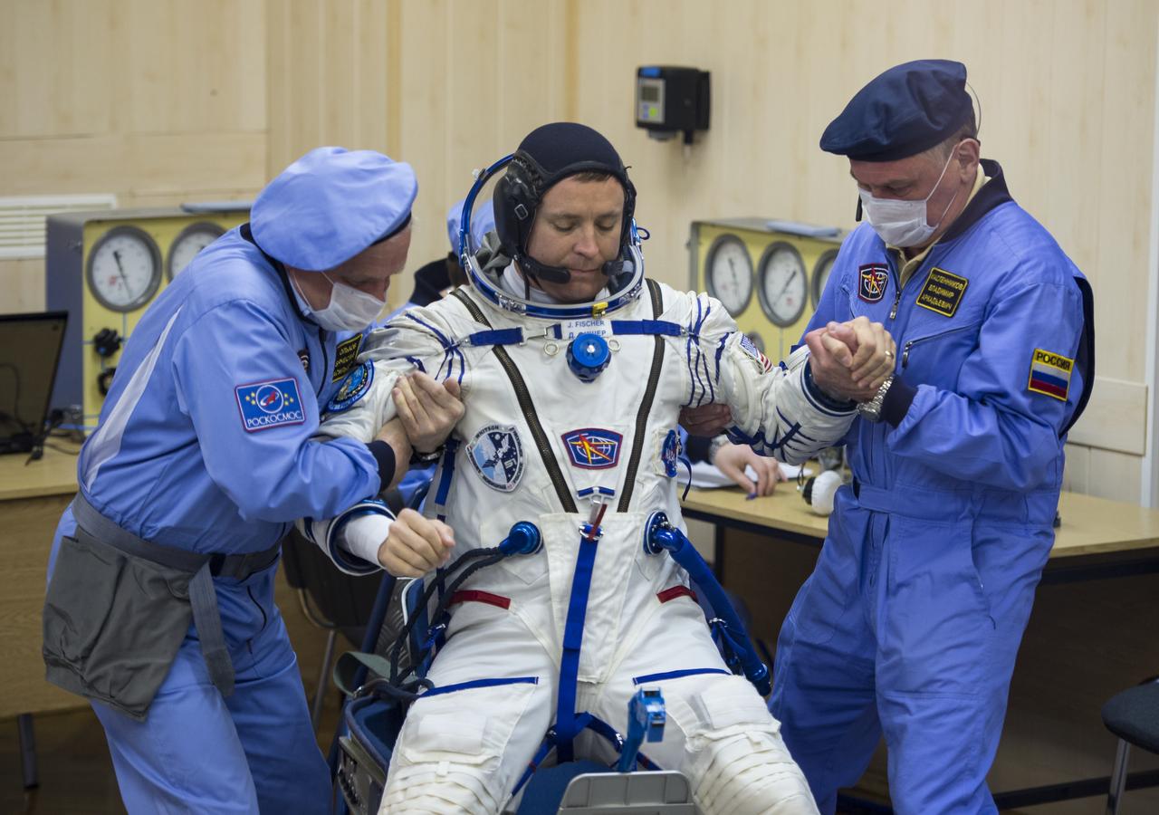 Expedition 51 Flight Engineer Jack Fischer of NASA is helped up after having his Russian Sokol suit pressure checked in preparation for his launch aboard the Soyuz MS-04 spacecraft on Thursday, April 20, 2017 at the Baikonur Cosmodrome in Kazakhstan. Launch of the Soyuz rocket is scheduled for 1:13pm April 20 Baikonur time, and will carry Fischer and fellow crewmate, Soyuz Commander Fyodor Yurchikhin of Roscosmos into orbit to begin their four and a half month mission on the International Space Station. Photo Credit: (NASA/Aubrey Gemignani)
