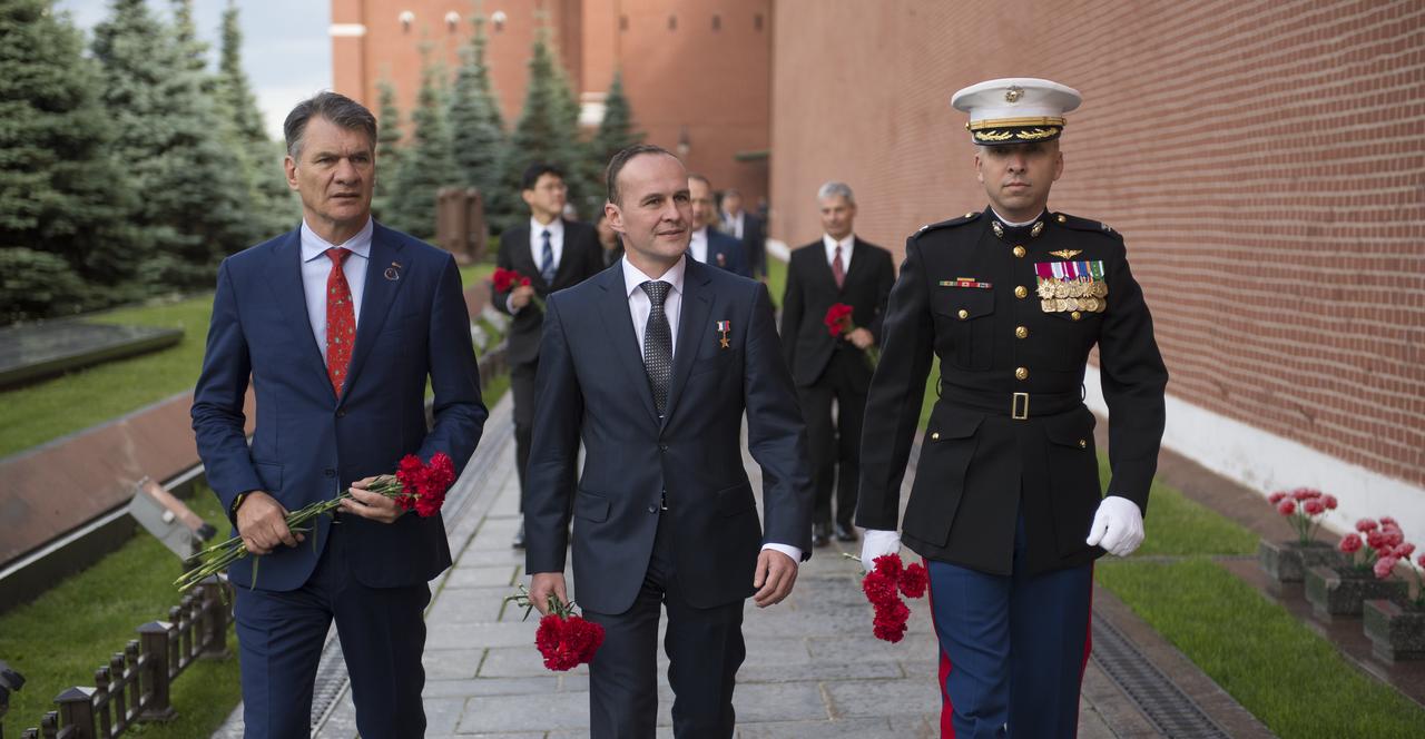Expedition 52 flight engineers Paolo Nespoli of ESA, left, Sergey Ryazanskiy of Roscosmos, center, and Randy Bresnik of NASA visit Red Square prepare to lay roses at the site where Russian space icons are interred as part of traditional pre-launch ceremonies, Monday, July 10, 2017 in Moscow. Photo Credit: (NASA/Bill Ingalls)