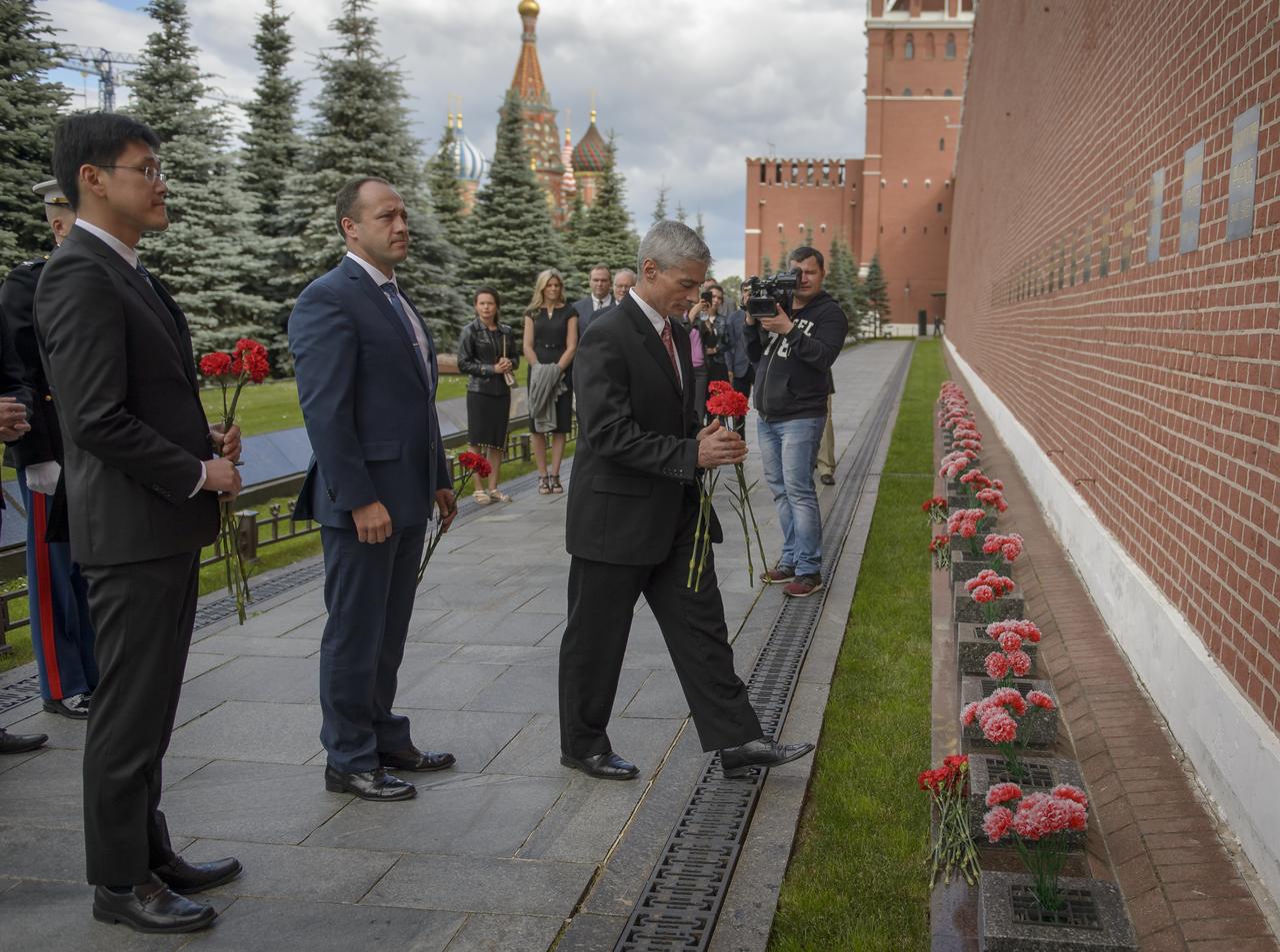 Expedition 52 backup crew members Norishige Kanai of the Japan Aerospace Exploration Agency (JAXA), left, Alexander Misurkin of Roscosmos, center, and Mark Vande Hei of NASA lay roses at the site where Russian space icons are interred as part of traditional pre-launch ceremonies, Monday, July 10, 2017 in Moscow. Photo Credit: (NASA/Bill Ingalls)