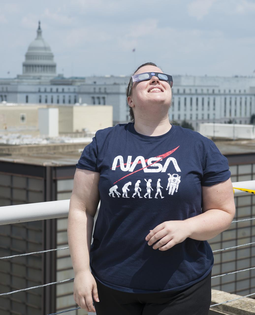 NASA employees and contractors use protective glasses to view a partial solar eclipse from NASA Headquarters Monday, Aug. 21, 2017 in Washington. A total solar eclipse swept across a narrow portion of the contiguous United States from Lincoln Beach, Oregon to Charleston, South Carolina. A partial solar eclipse was visible across the entire North American continent along with parts of South America, Africa, and Europe.  Photo Credit: (NASA/Gwen Pitman)