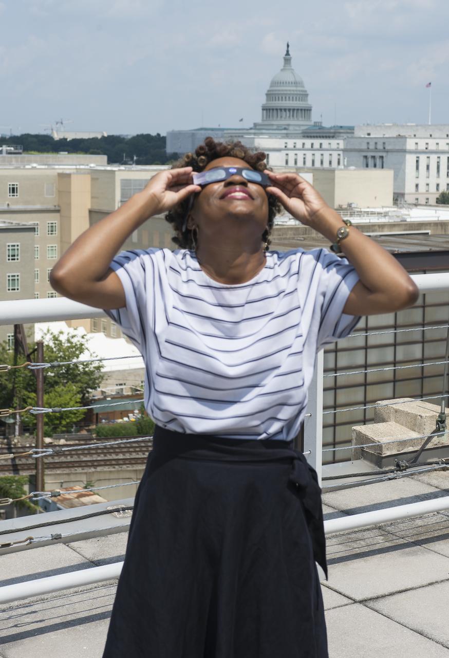 NASA employees and contractors use protective glasses to view a partial solar eclipse from NASA Headquarters Monday, Aug. 21, 2017 in Washington. A total solar eclipse swept across a narrow portion of the contiguous United States from Lincoln Beach, Oregon to Charleston, South Carolina. A partial solar eclipse was visible across the entire North American continent along with parts of South America, Africa, and Europe.  Photo Credit: (NASA/Gwen Pitman)