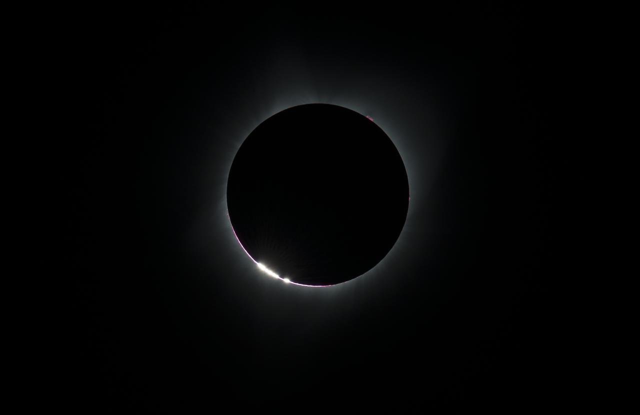 The Baily's Beads  effect is seen as the moon makes its final move over the sun during the total solar eclipse on Monday, August 21, 2017 above Madras, Oregon. A total solar eclipse swept across a narrow portion of the contiguous United States from Lincoln Beach, Oregon to Charleston, South Carolina. A partial solar eclipse was visible across the entire North American continent along with parts of South America, Africa, and Europe.  Photo Credit: (NASA/Aubrey Gemignani)