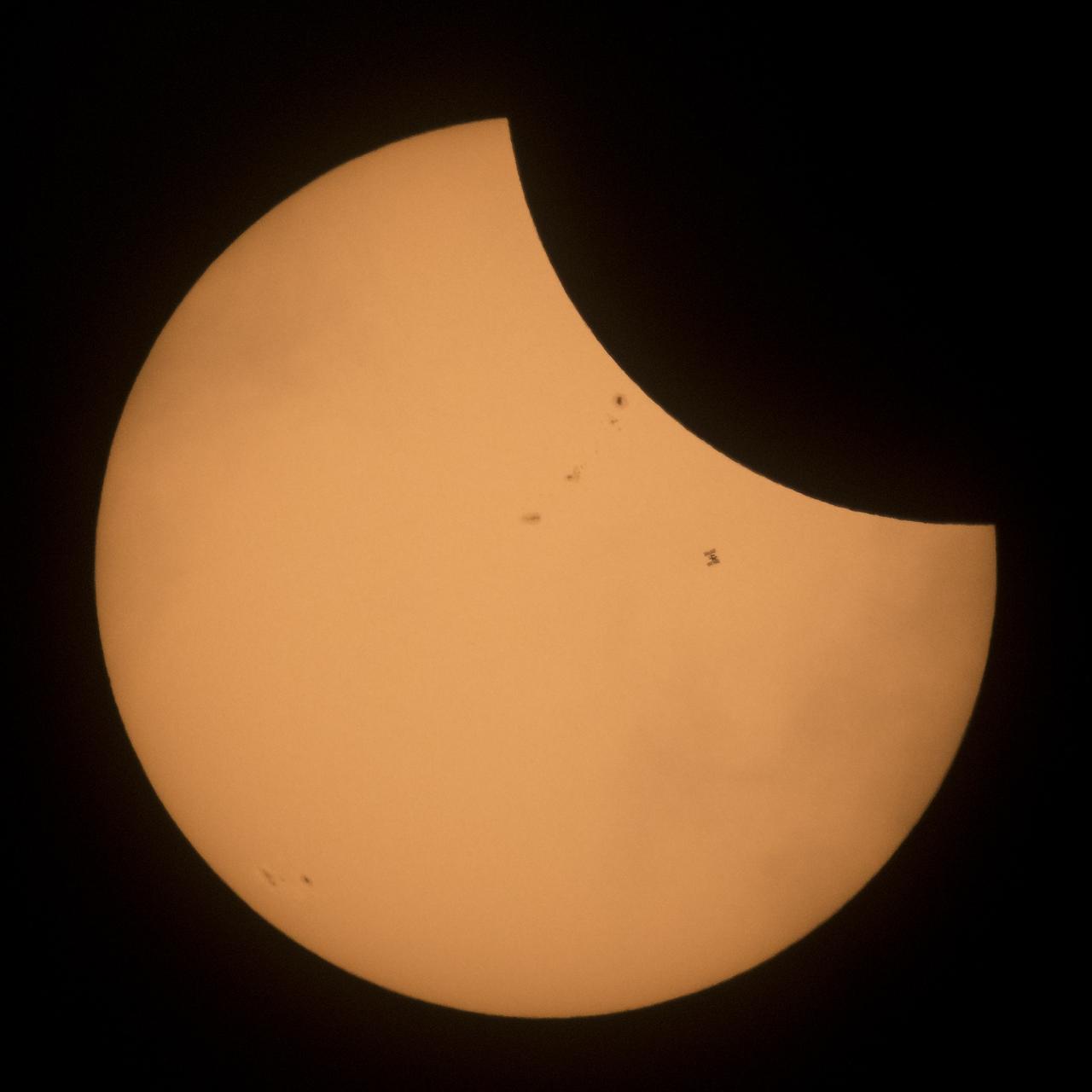 The International Space Station, with a crew of six onboard, is seen in silhouette as it transits the Sun at roughly five miles per second during a partial solar eclipse, Monday, Aug. 21, 2017 near Banner, Wyoming.  Onboard as part of Expedition 52 are: NASA astronauts Peggy Whitson, Jack Fischer, and Randy Bresnik; Russian cosmonauts Fyodor Yurchikhin and Sergey Ryazanskiy; and ESA (European Space Agency) astronaut Paolo Nespoli. A total solar eclipse swept across a narrow portion of the contiguous United States from Lincoln Beach, Oregon to Charleston, South Carolina. A partial solar eclipse was visible across the entire North American continent along with parts of South America, Africa, and Europe.  Photo Credit: (NASA/Joel Kowsky)