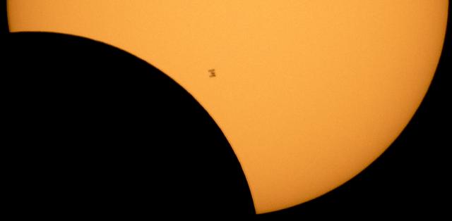 The International Space Station, with a crew of six onboard, is seen in silhouette as it transits the Sun at roughly five miles per second during a partial solar eclipse, Monday, Aug. 21, 2017 from Ross Lake, Northern Cascades National Park, Washington.  Onboard as part of Expedition 52 are: NASA astronauts Peggy Whitson, Jack Fischer, and Randy Bresnik; Russian cosmonauts Fyodor Yurchikhin and Sergey Ryazanskiy; and ESA (European Space Agency) astronaut Paolo Nespoli. A total solar eclipse swept across a narrow portion of the contiguous United States from Lincoln Beach, Oregon to Charleston, South Carolina. A partial solar eclipse was visible across the entire North American continent along with parts of South America, Africa, and Europe.  Photo Credit: (NASA/Bill Ingalls)