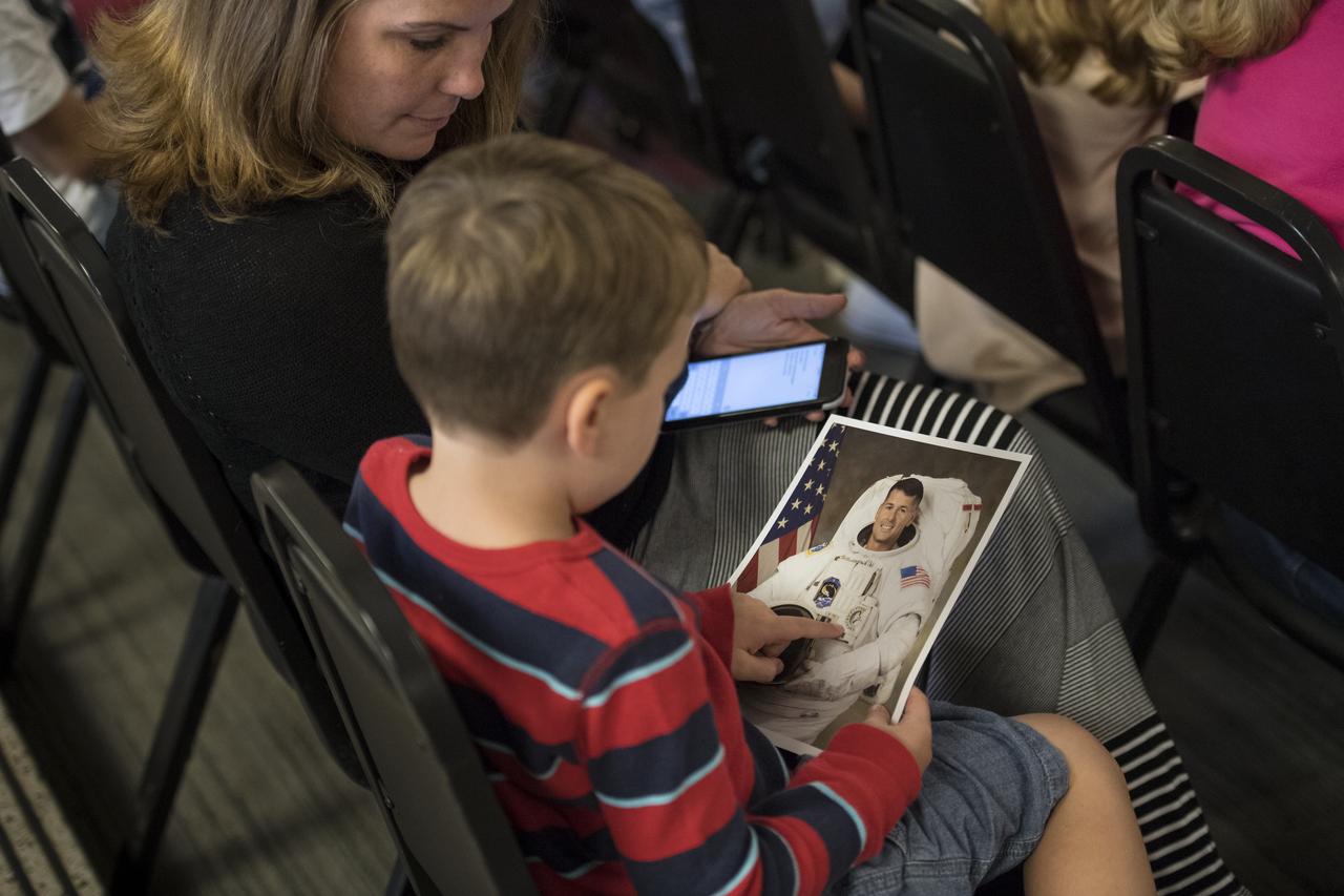 A young audience member examines the photo of NASA astronaut Shane Kimbrough during a presentation about his time onboard the International Space Station (ISS) during Expeditions 49/50, Tuesday, September 12, 2017 at Arlington Career Center in Arlington, Virginia. During Expedition 50, Kimbrough completed four spacewalks for a total of 39 hours outside the ISS, and concluded his 173-day mission when he landed in a remote area near the town of Zhezkazgan, Kazakhstan in April 2017. Photo Credit: (NASA/Aubrey Gemignani)